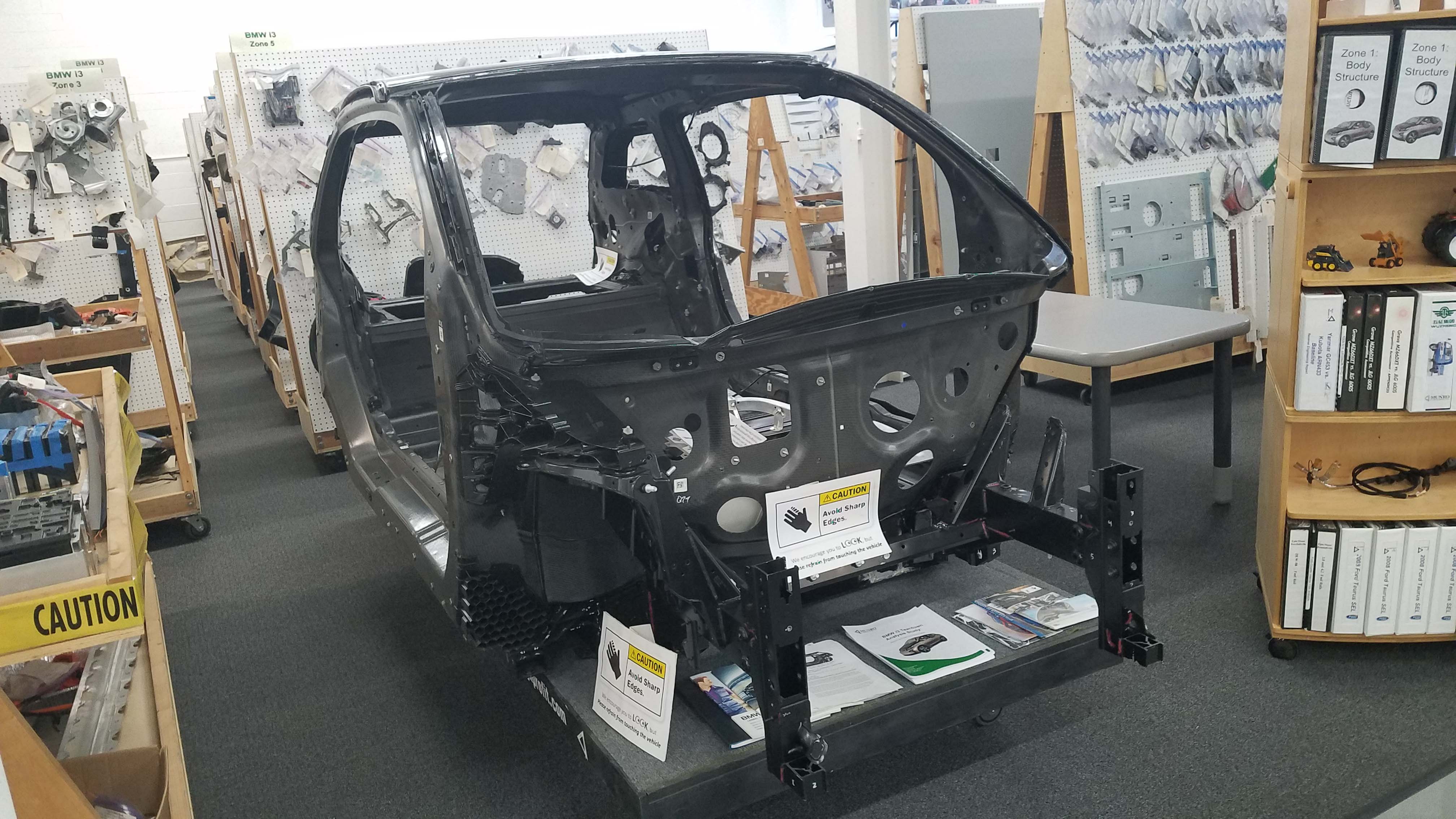 Munro & Associates dis-assembles multiple cars for evaluation. This is a BMW i3 chassis stripped down to its carbon-fiber backbone.