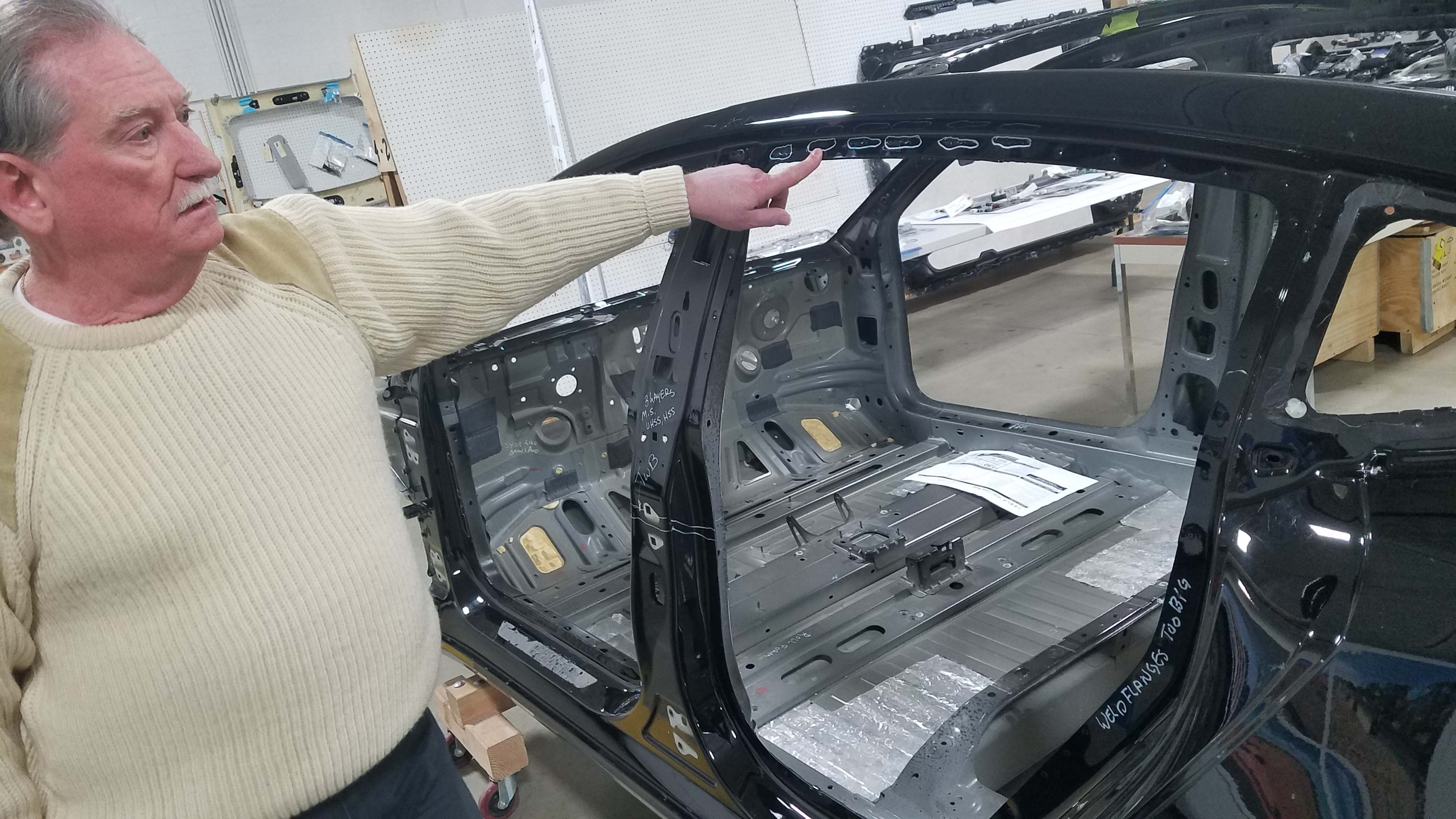Munro & Assoc. CEP Sandy Munro points out the three different fastening systems for the Tesla Model 3 rear door fame - an example of the manufacturing complexity required of the Tesla.