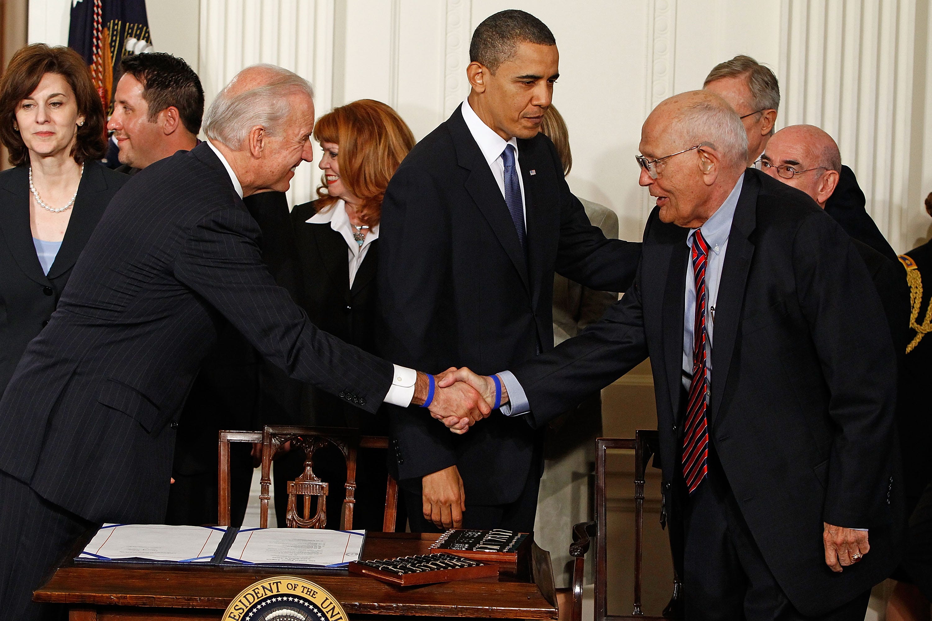 Vice President Joe Biden and President Barack Obama shake hands with Dingell before Obama signs the Affordable Health Care for America Act during a ceremony in the White House March 23, 2010. Dingell had introduced national health insurance legislation for more than 50 years before he finally saw it become law.