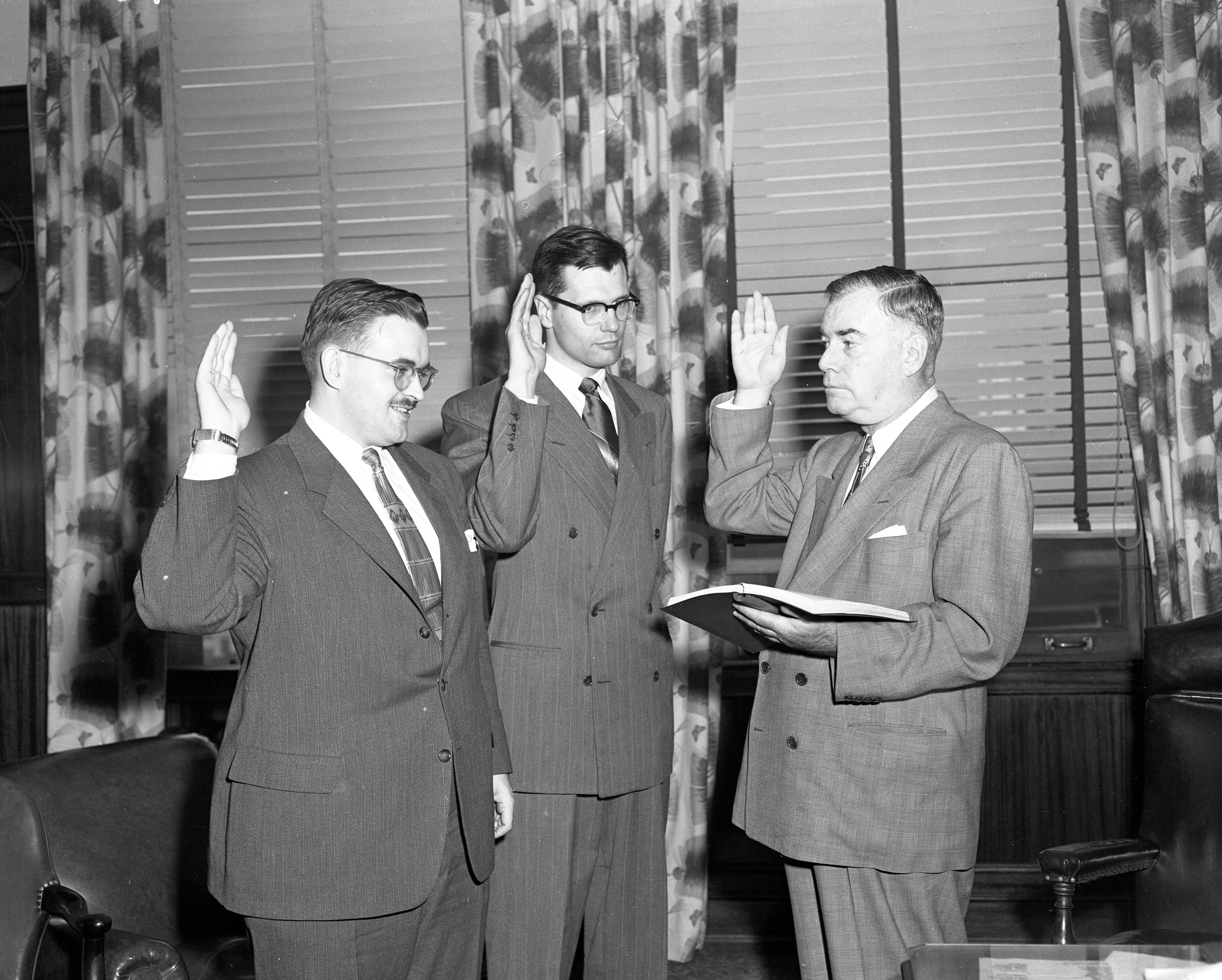 In 1953, John Dingell Jr., center, and William J. Coughlin, left, take the oath of office from Gerald O'Brien. Dingell would serve as an assistant prosecuting attorney for Wayne County until 1955.