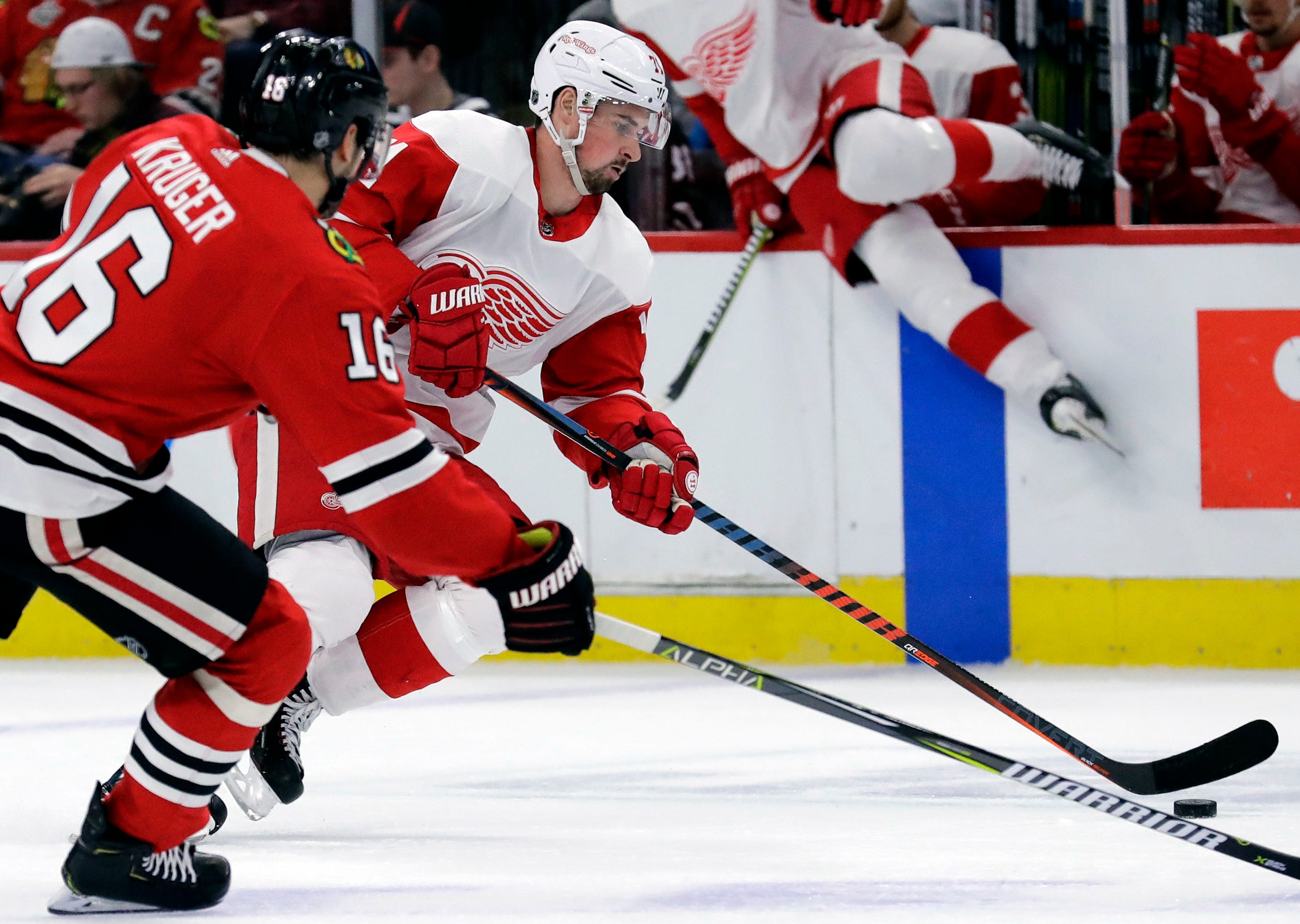 Detroit Red Wings center Dylan Larkin, front right, controls the puck against Chicago Blackhawks center Marcus Kruger, left, during the first period.
