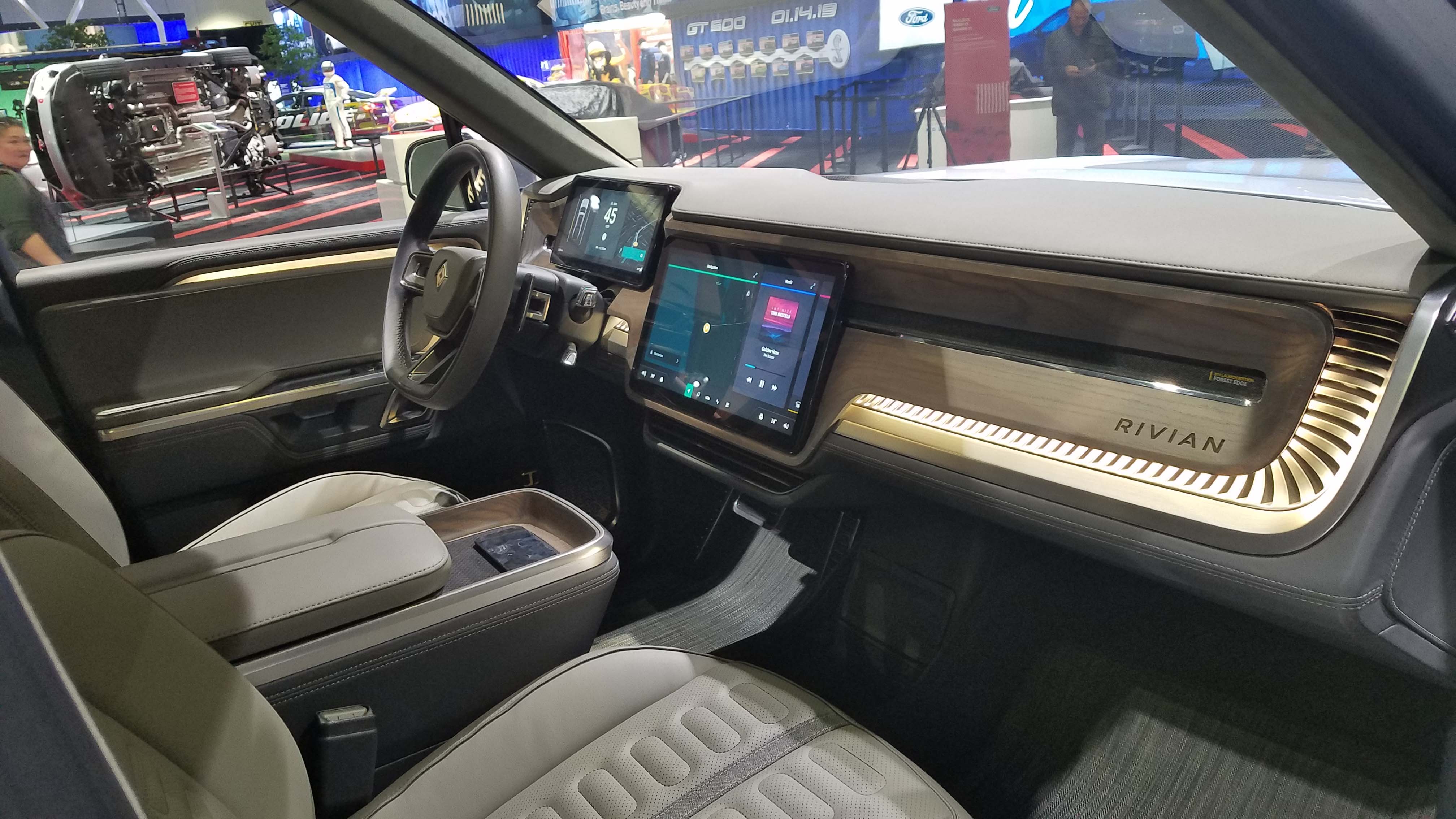 The interior of the Rivian R1T pickup featues big, digital screens and generous use of wood trim. In addition to 400 miles of range the truck offers Level 3 autonomous driving.