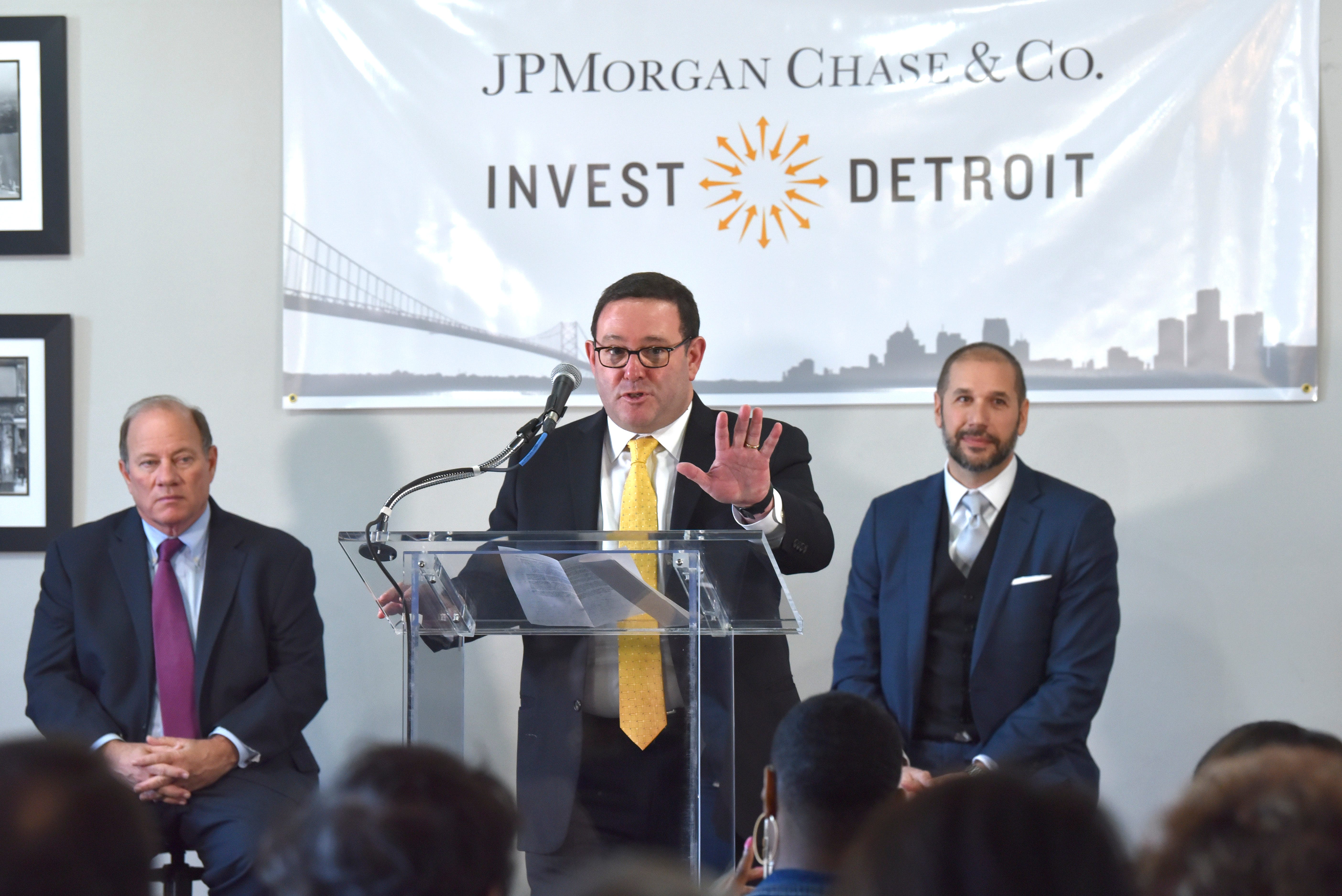 Peter Scher, center, head of corporate responsibility at JPMorgan Chase, announces a $15 investment in Detroit neighborhoods as Detroit Mayor Mike Duggan, left, and Invest Detroit CEO Dave Blaszkiewicz, right, listen.