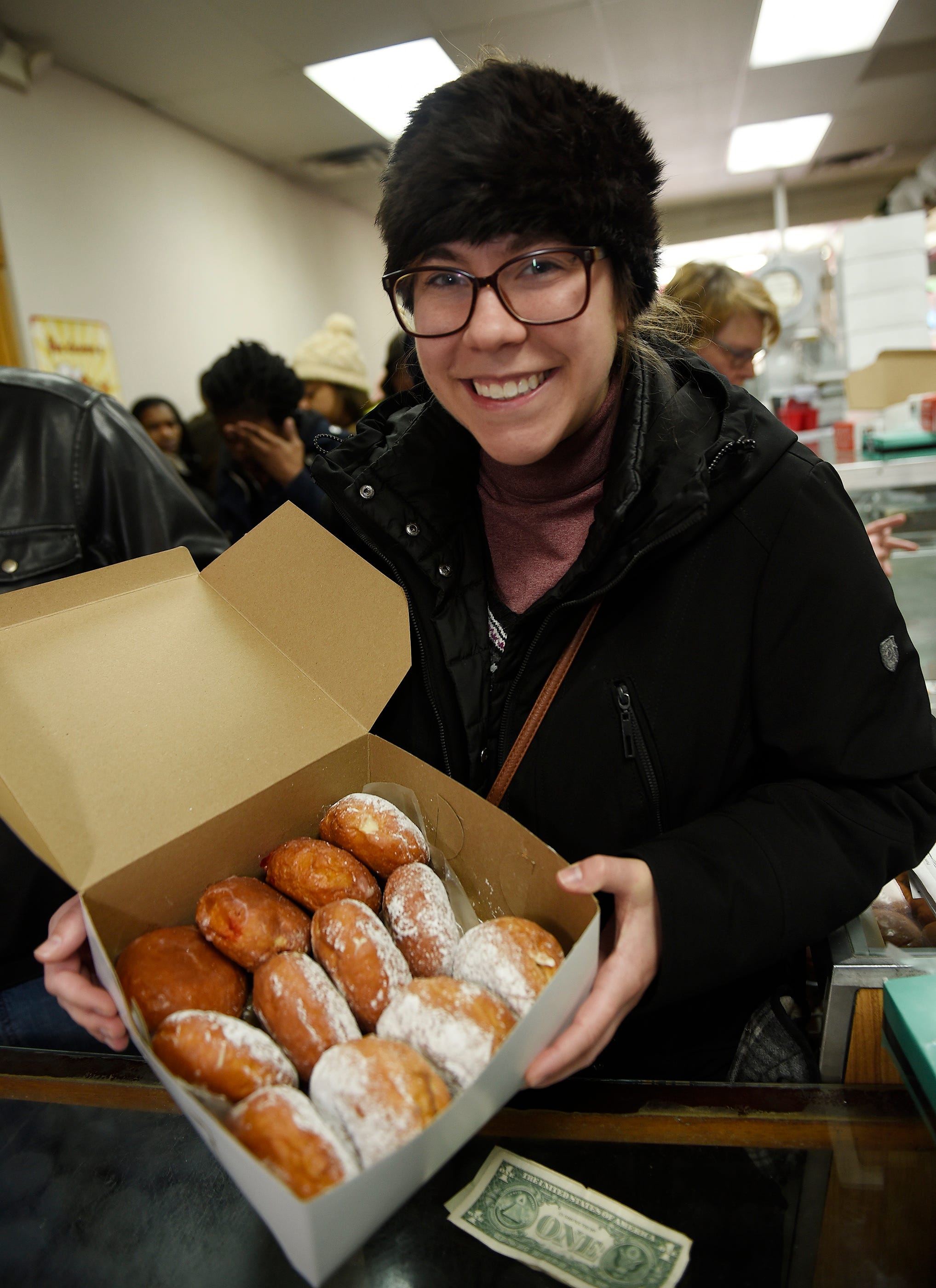 Erin Harris, 26, of Hamtramck displays a dozen of paczki that she will be taking to work for her colleagues.