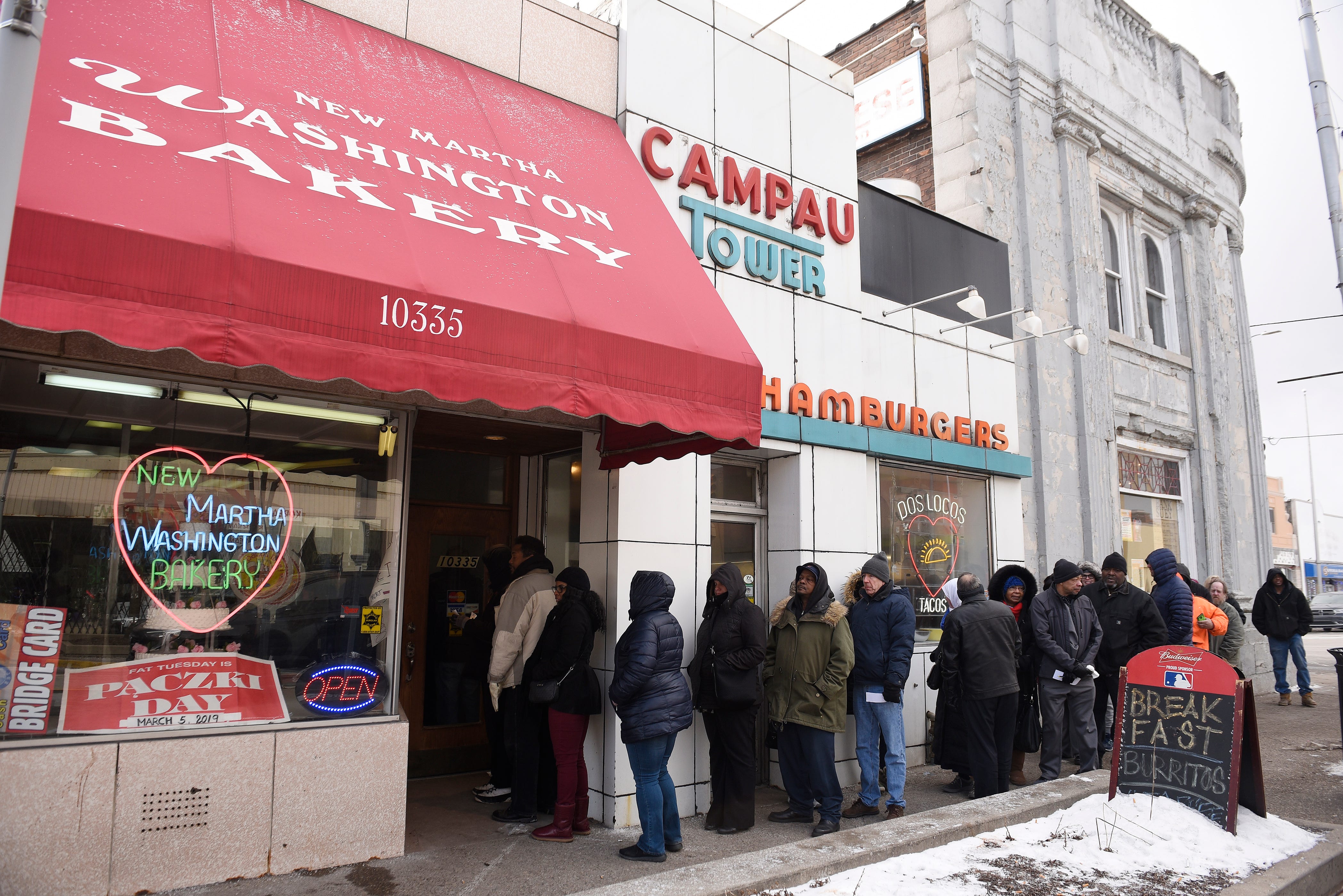 A long line of customers wait to enter the New Martha Washington Bakery to purchase their paczki.