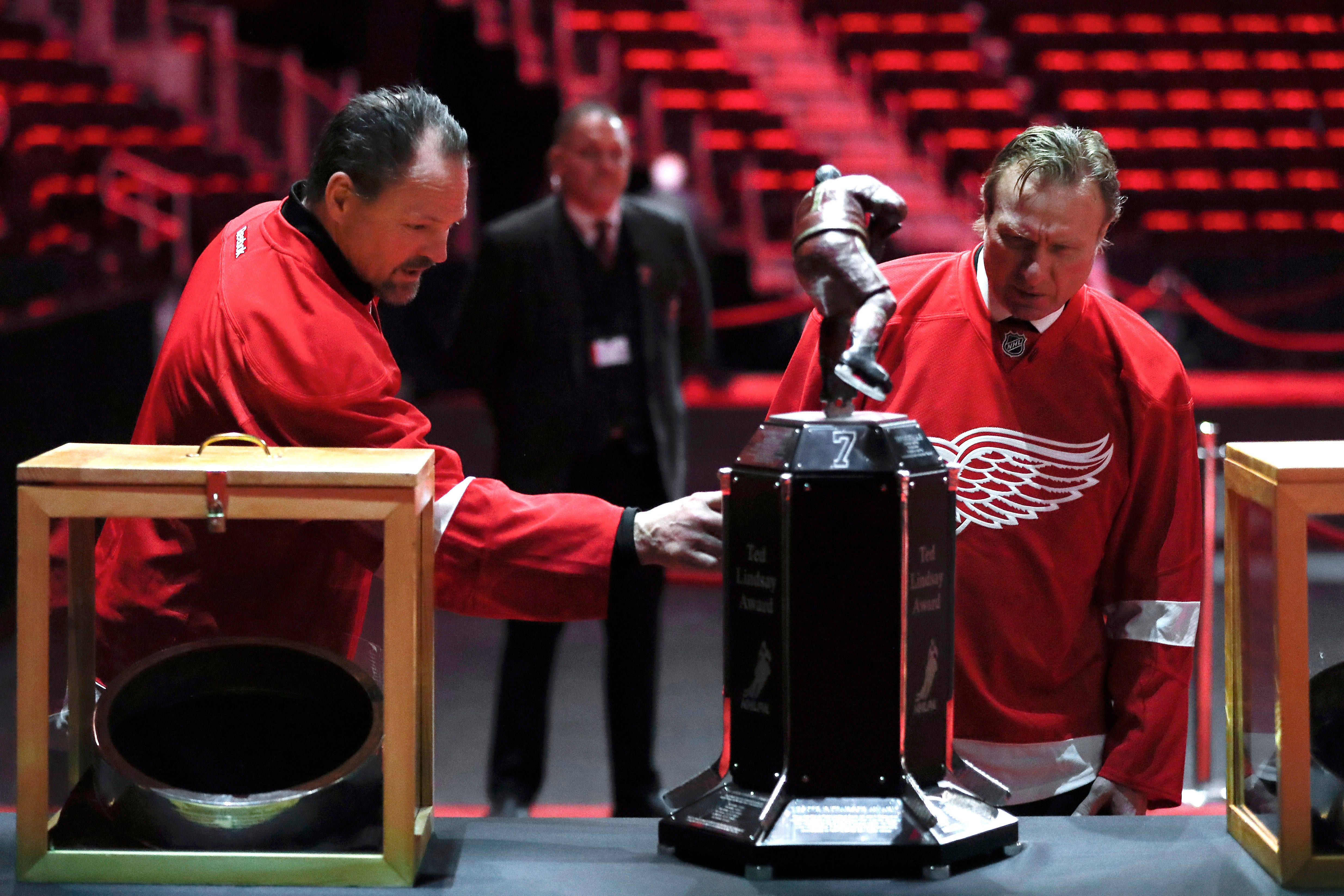 Former Detroit Red Wings players Joe Kocur and Eddie Mio view memorabilia at the public viewing for Ted Lindsay.