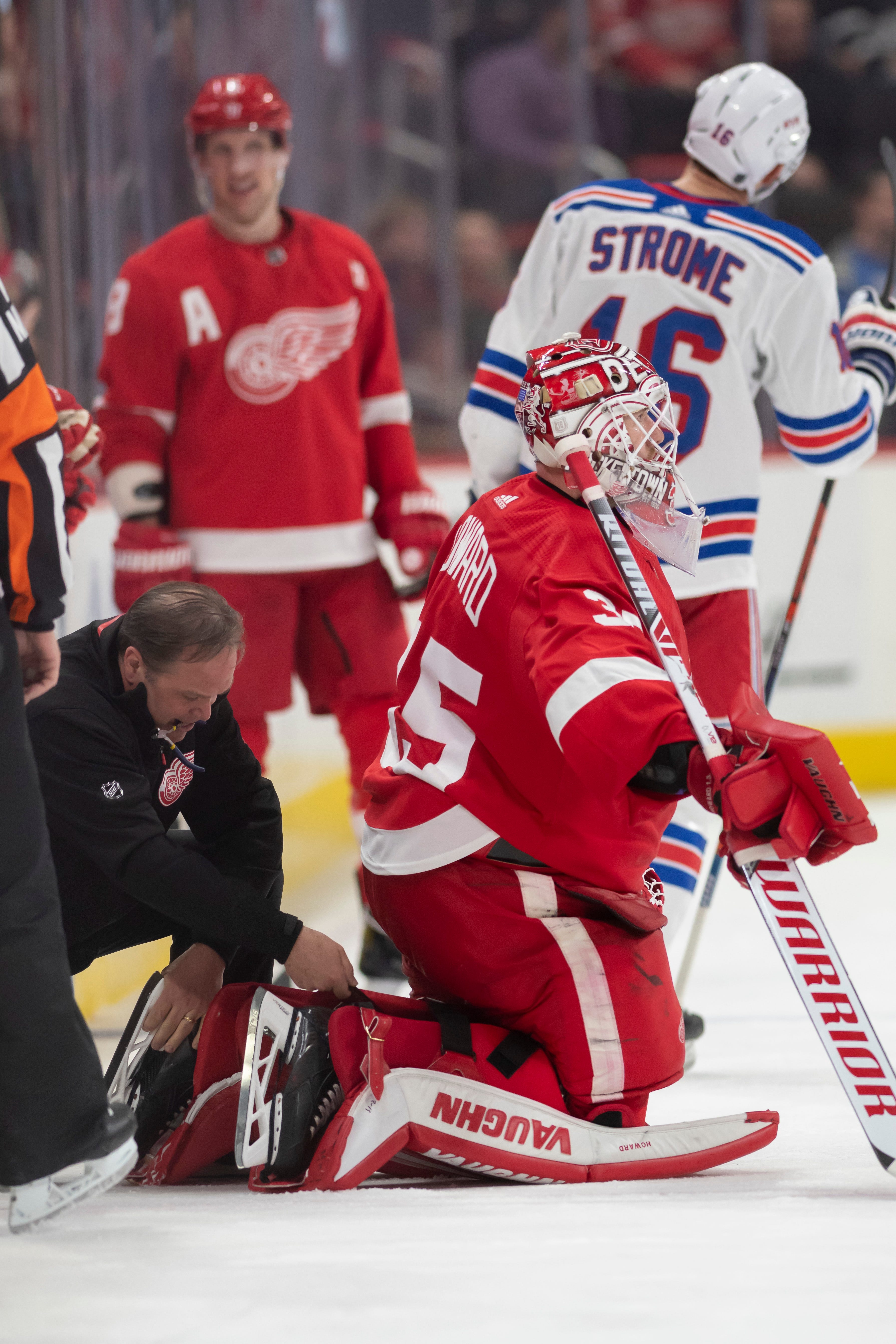 Equipment manager Paul Boyer makes a quick blade change for goaltender Jimmy Howard in the third period.