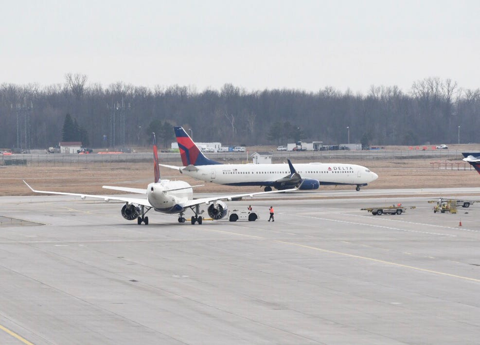 Passengers on a Delta flight from Indianapolis to Detroit Metro Airport restrained a woman who tried to open the plan door shortly after take-off, officials say.