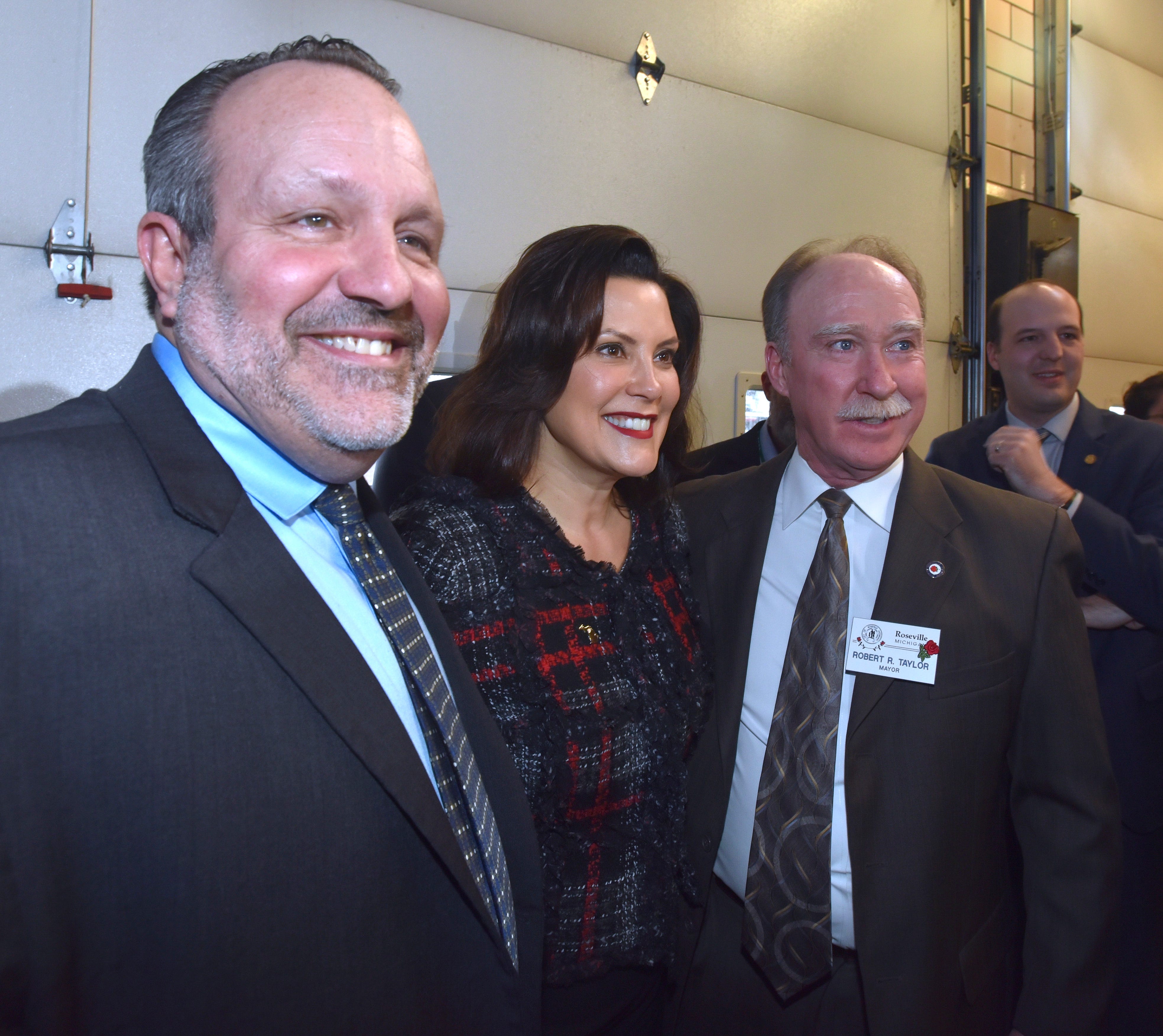 Center Line Mayor Robert Binson, left, and Roseville Mayor Robert Taylor, right, pose with Michigan Governor Gretchen Whitmer, center, after the press conference.