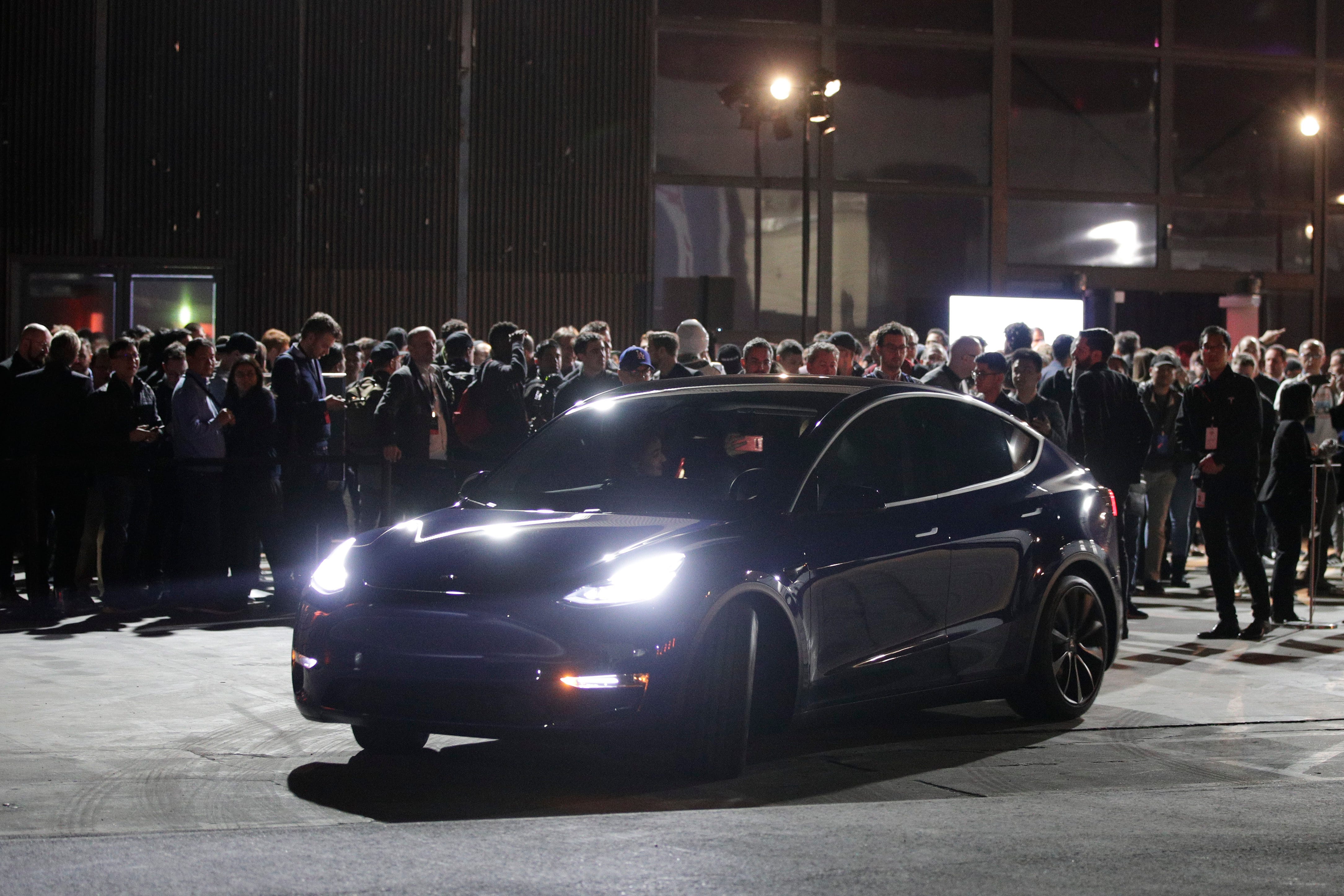 People wait outside Tesla's design studio for a test drive of the Model Y, Thursday, March 14, 2019, in Hawthorne, Calif. T