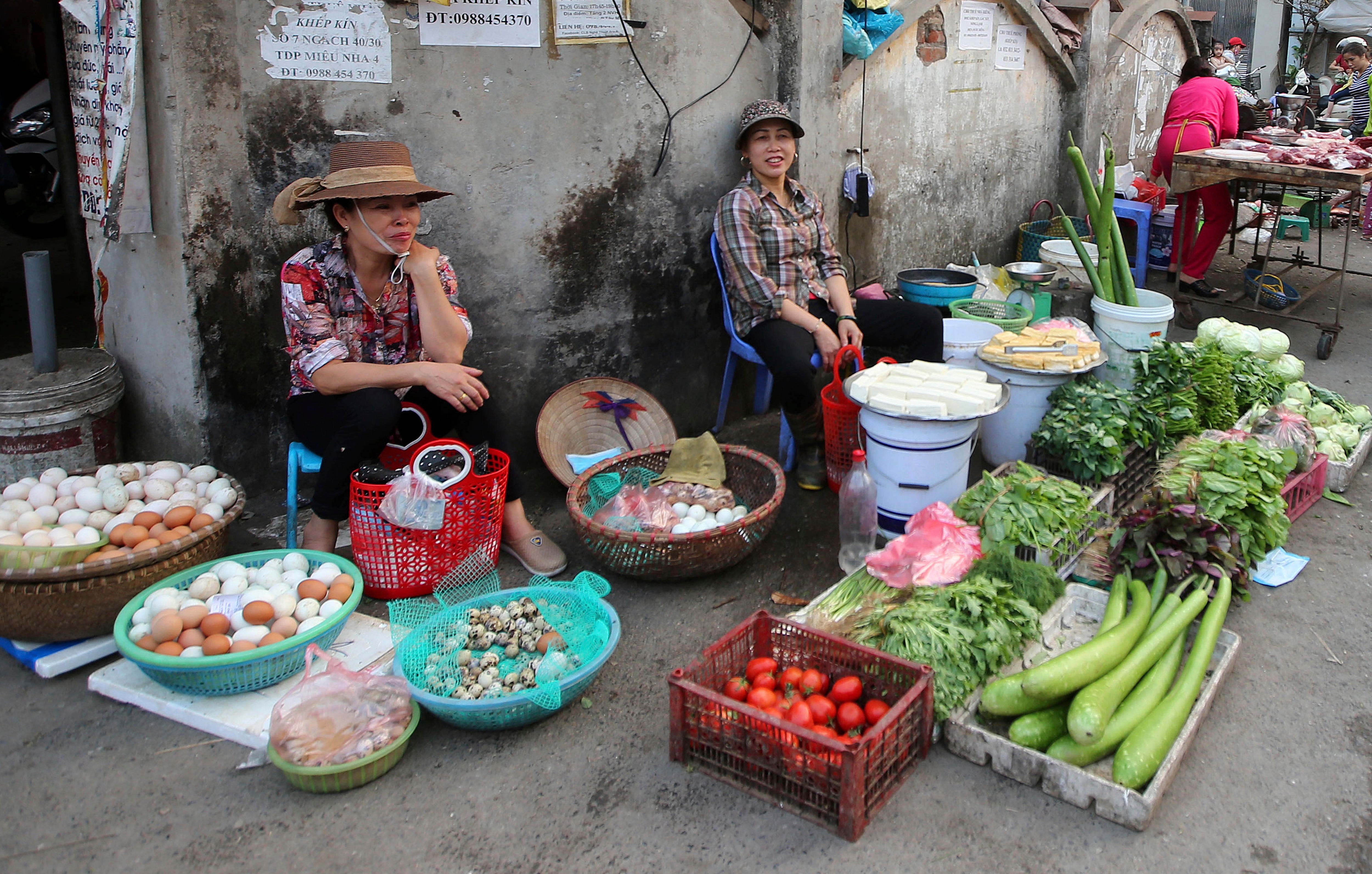 A woman sells vegetables at an outdoor market in Hanoi, Vietnam, Thursday, Feb. 21, 2019. Vietnam, the location of President Donald Trump's next meeting with North Korean leader Kim Jong Un, has come along way since the Us abandoned its war against communist North Vietnam in the 1970s. (AP Photo/Minh Hoang)