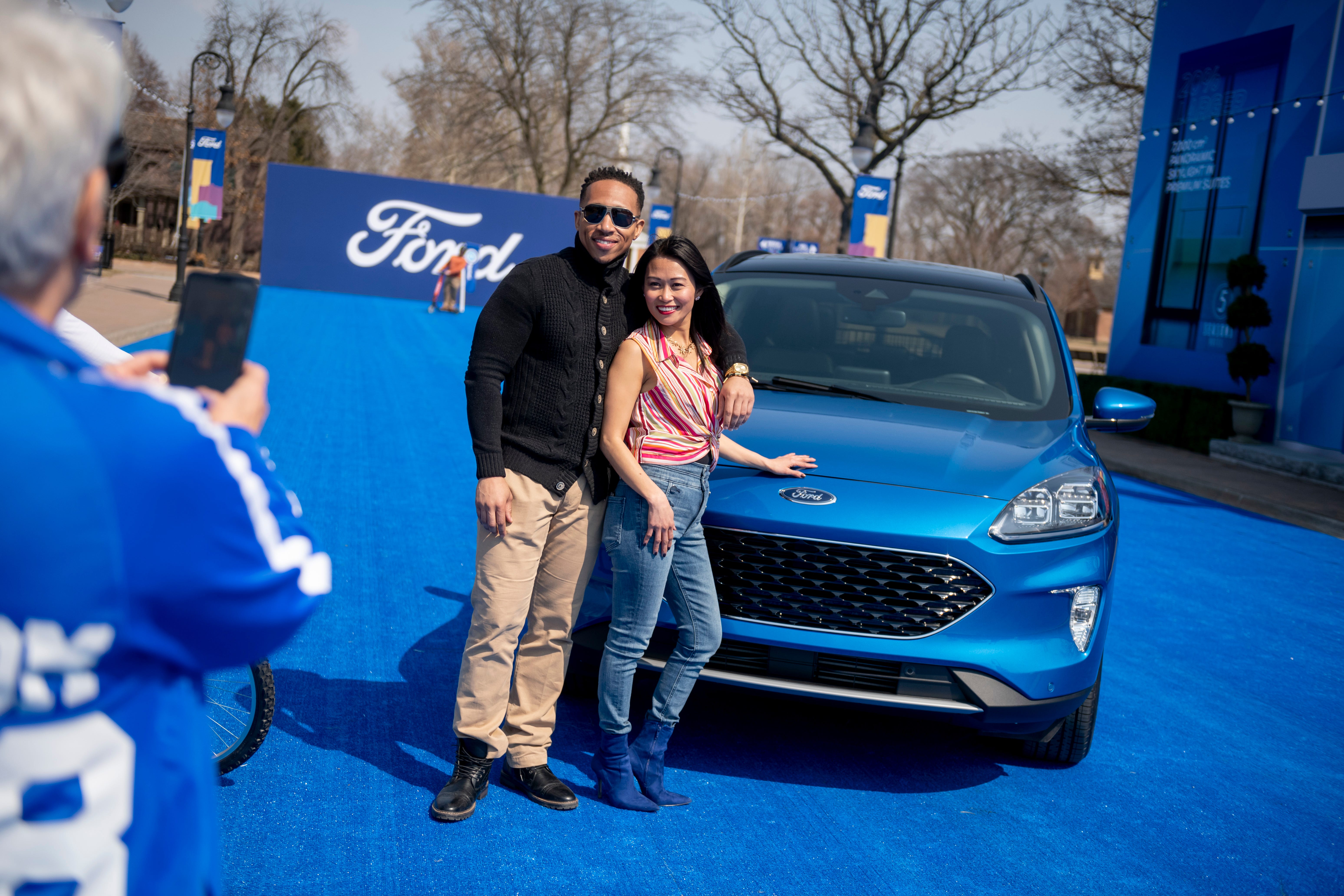 Performers Nigel Morris, left, and Jovie Clark pose for a photograph in front of the 2020 Ford Escape, during a reveal at Greenfield Village, in Dearborn.
