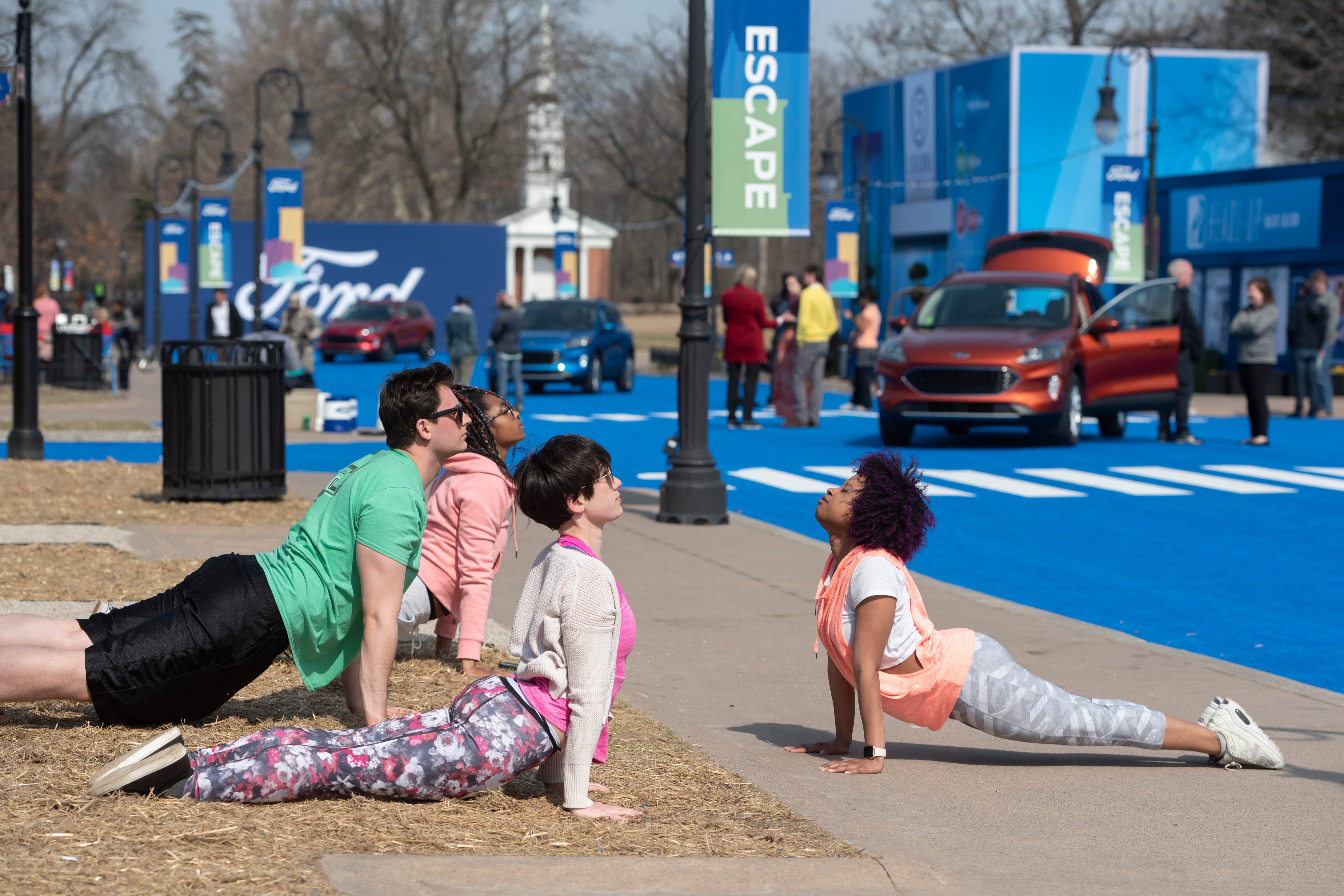 Actors perform the act of participating in a yoga class during a reveal of the 2020 Ford Escape, at Greenfield Village. The performers simulated potentially real scenarios from everyday living.