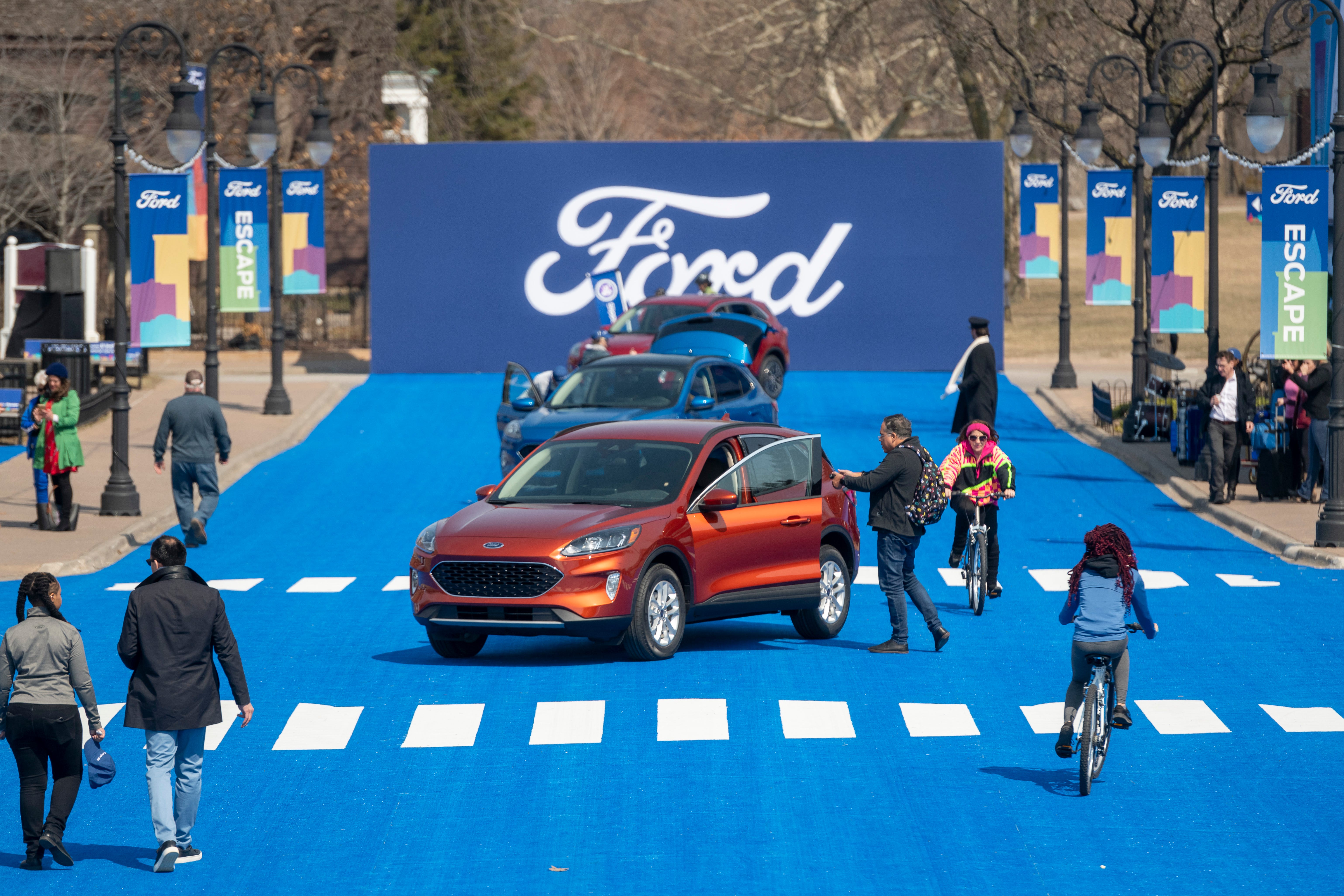 Performers, artists and journalists roam around Greenfield Village during a reveal of the 2020 Ford Escape.