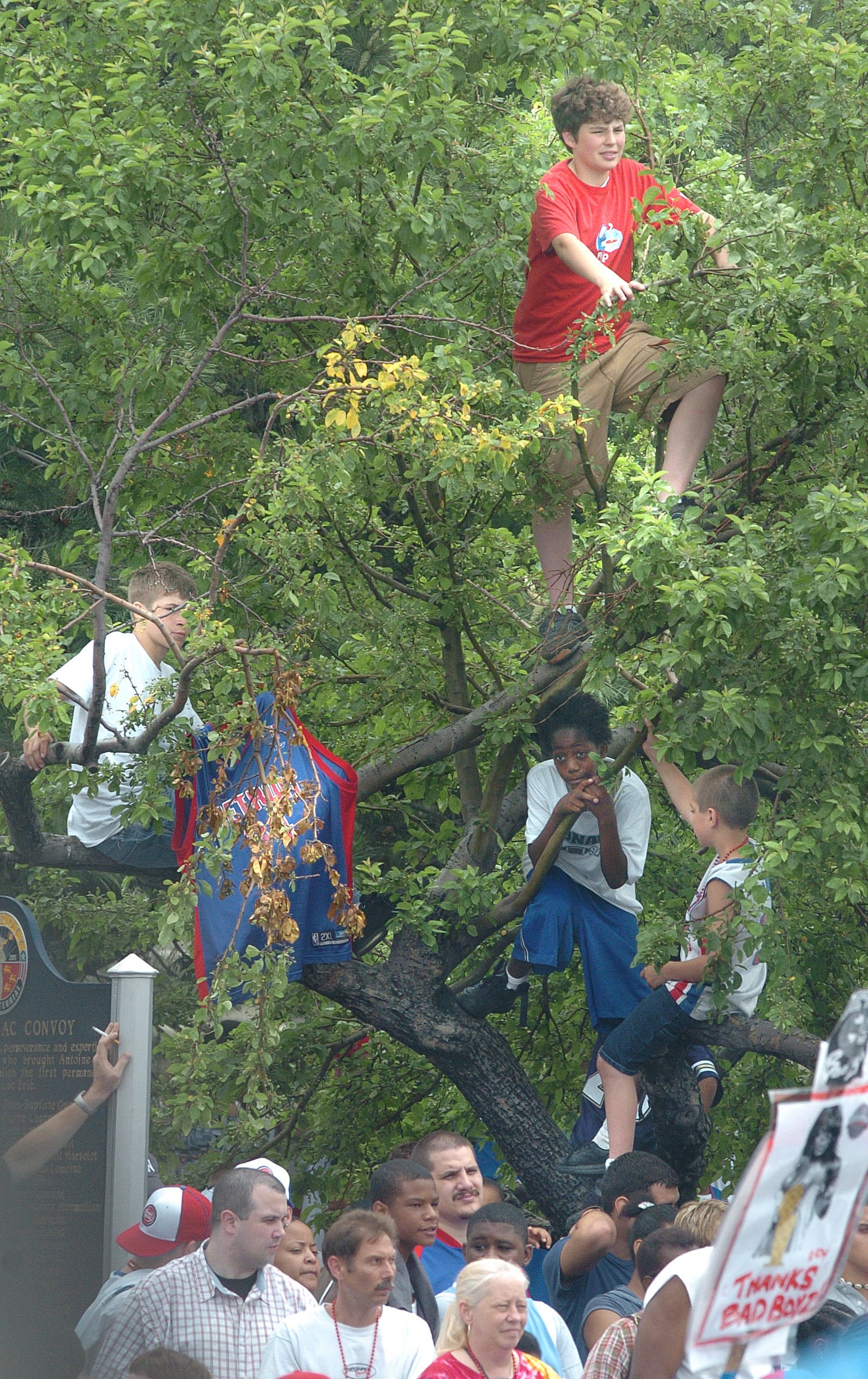 Kids climb up into the trees in Hart Plaza for a better view.