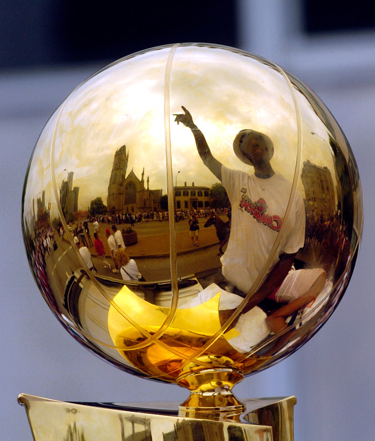 Ben Wallace is reflected in the NBA championship trophy during the parade on Thursday, June 17, 2004.