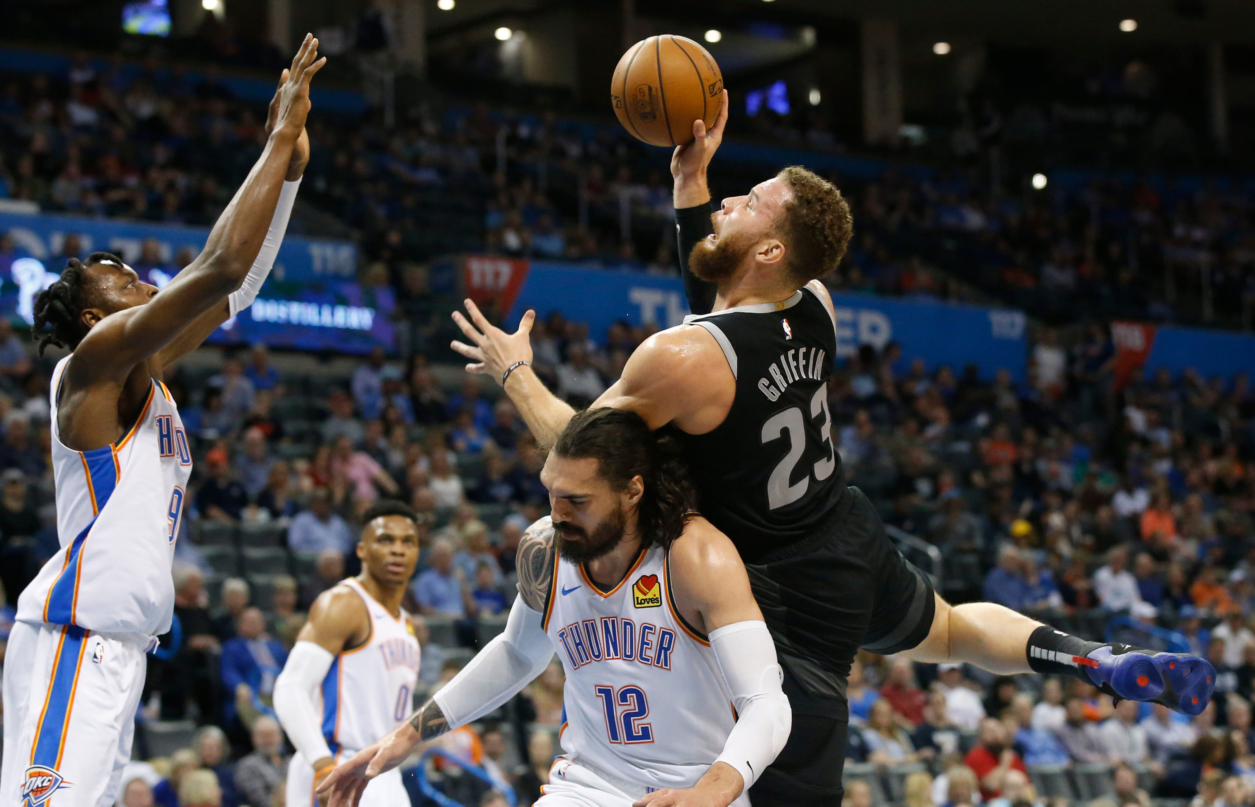 Detroit Pistons forward Blake Griffin (23) is fouled by Oklahoma City Thunder center Steven Adams (12) as he shoots in front of forward Jerami Grant, left, during the first half.