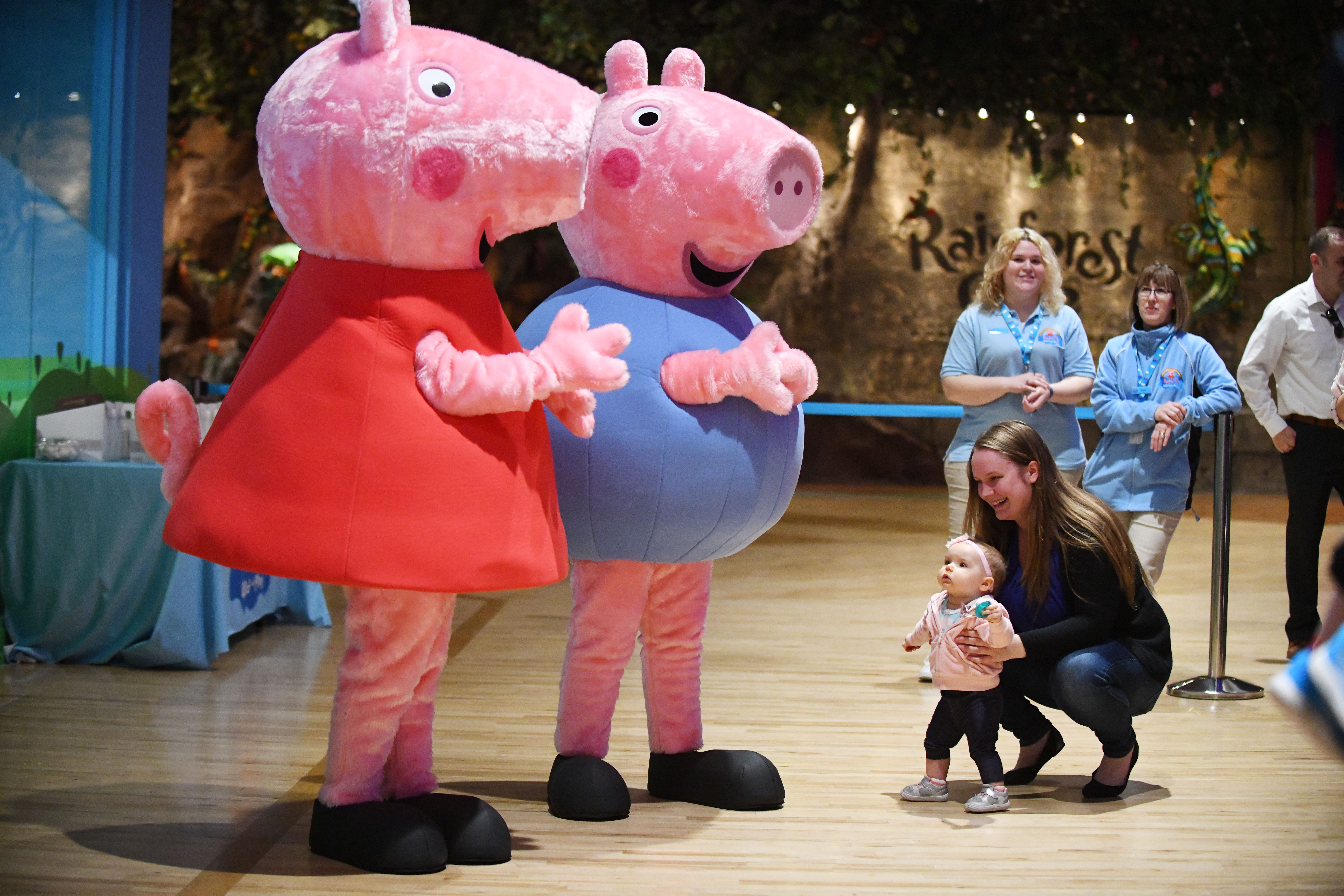 Christina Schafer with daughter Athena Schafer, 10 months, meet Peppa and George during the grand opening of the Peppa Pig World of Play on Tuesday at Great Lakes Crossing.