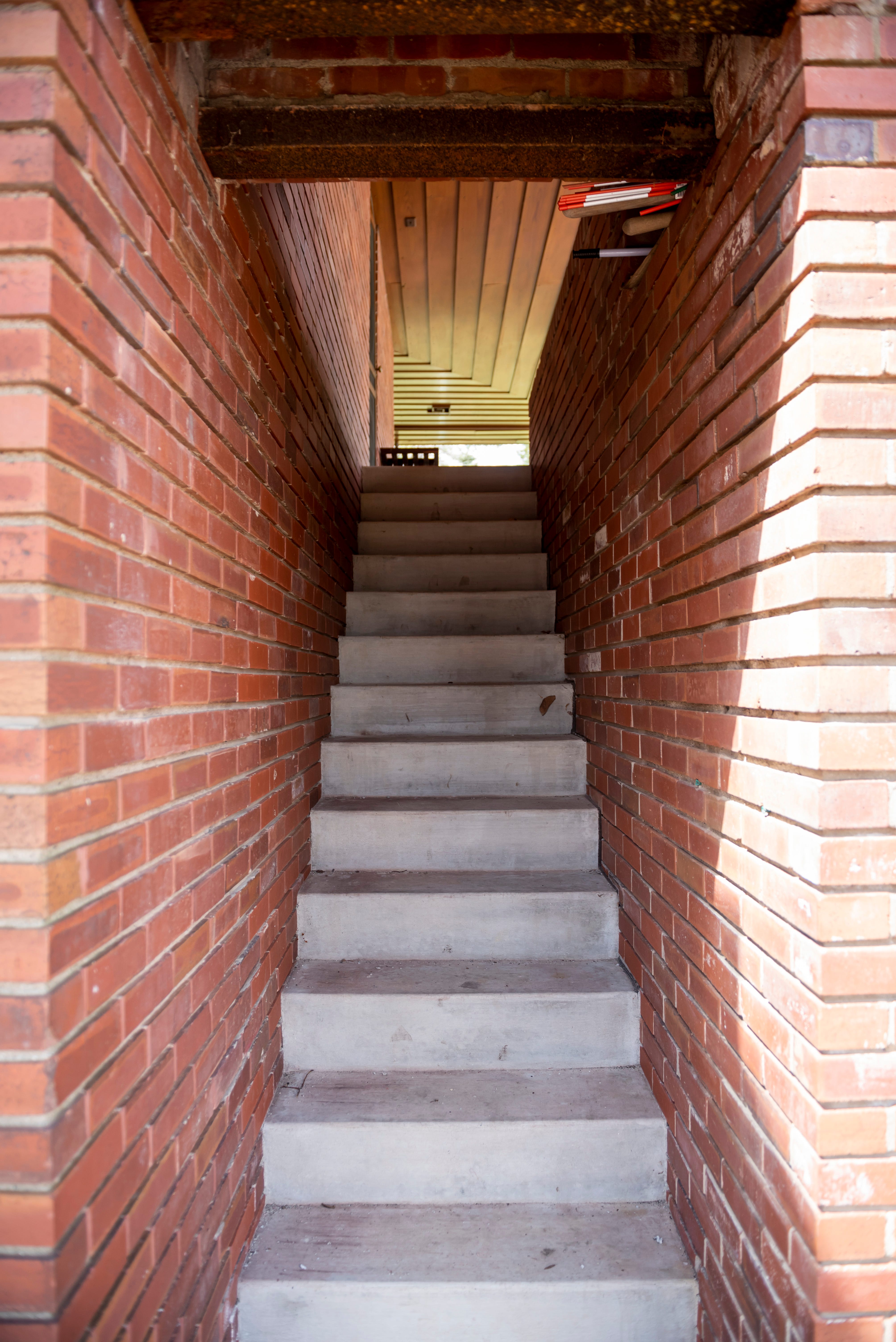 A skinny stairwell leads from the carport to the grounds.