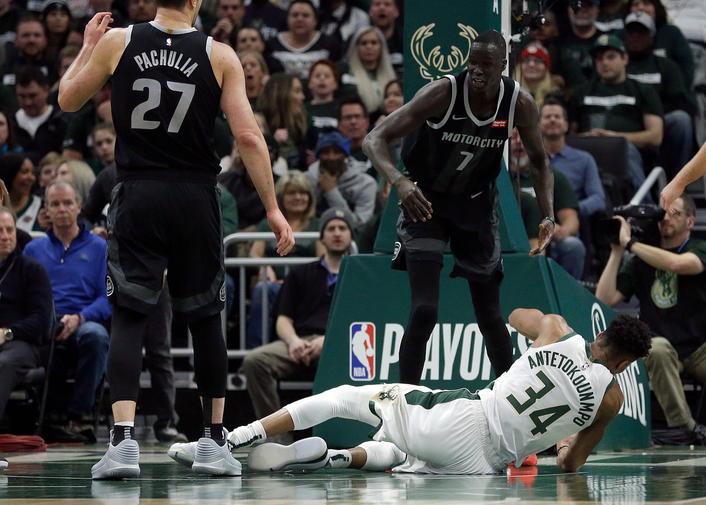 Bucks ' Giannis Antetokounmpo (34) falls to the floor after being fouled by Pistons ' Thon Maker (7) during the first half.
