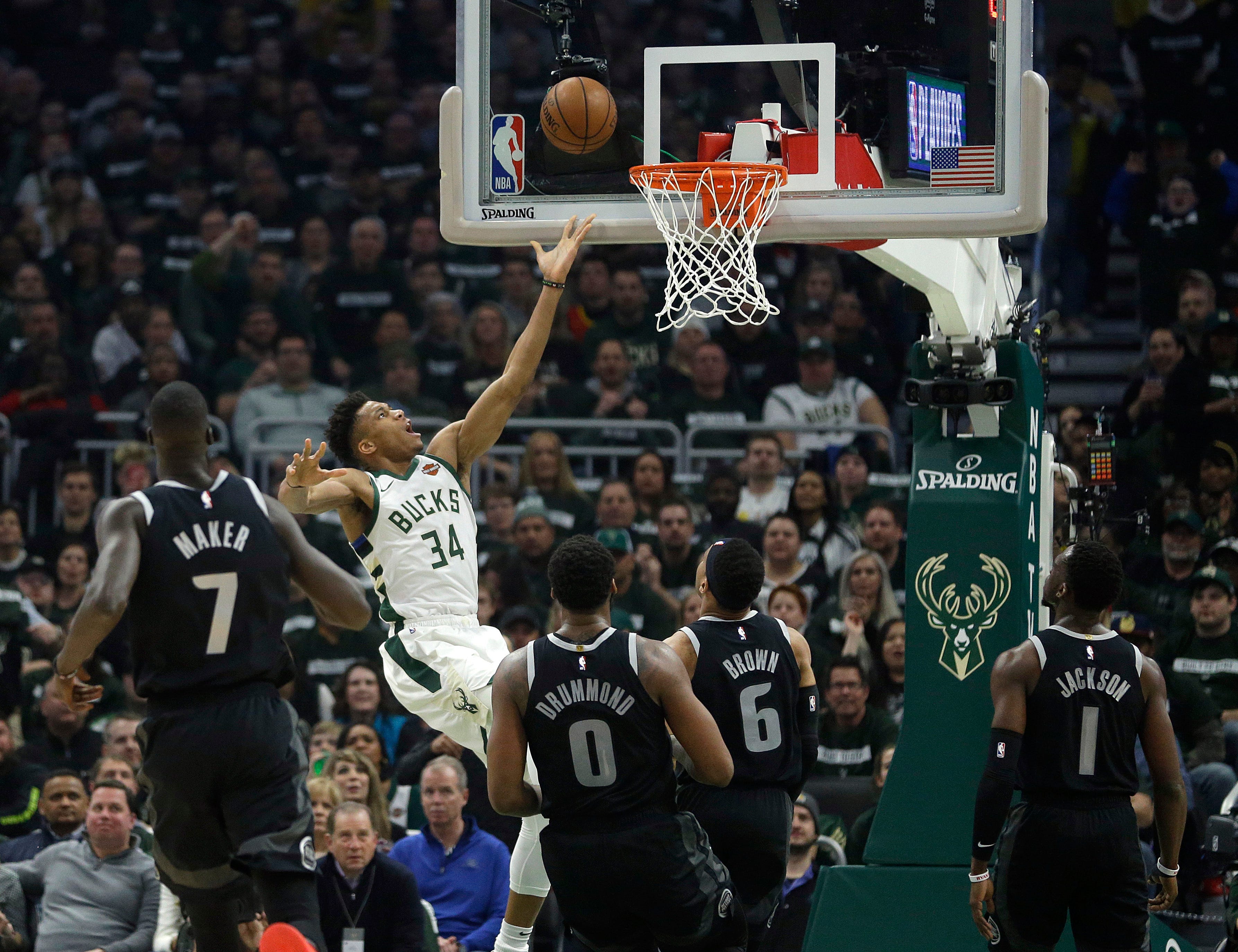 Bucks ' Giannis Antetokounmpo (34) shoots against multiple Pistons defenders during the first half.