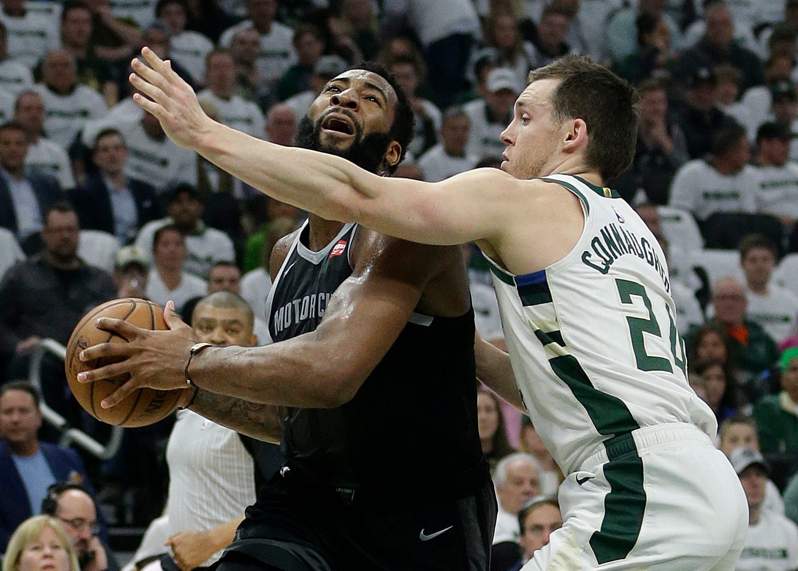 Pistons ' Andre Drummond, left, drives to the basket against Bucks ' Pat Connaughton during the first half.