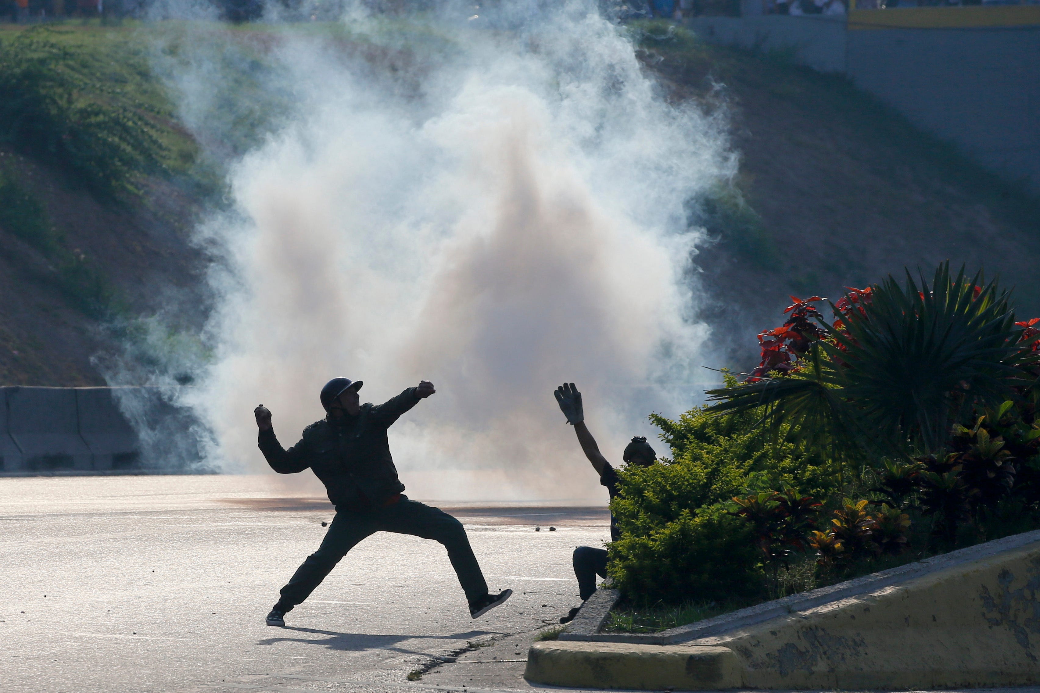 Opponents to Venezuela ' s President Nicolas Maduro throw stones at soldiers loyal to the president in Caracas, Venezuela, April 30, 2019.