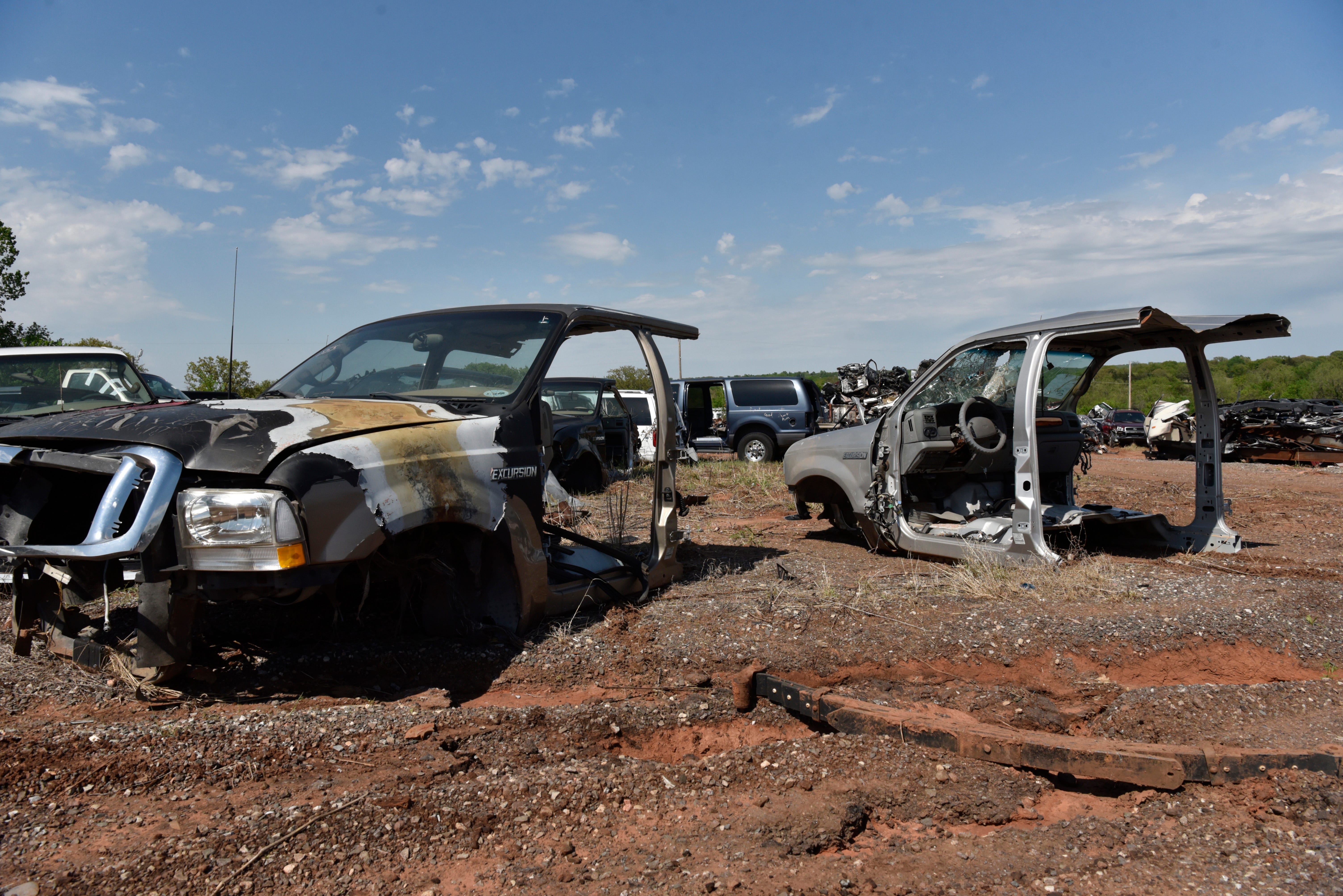 The remains of Ford Excursion bodies that were converted into new vehicles sit in the back lot.