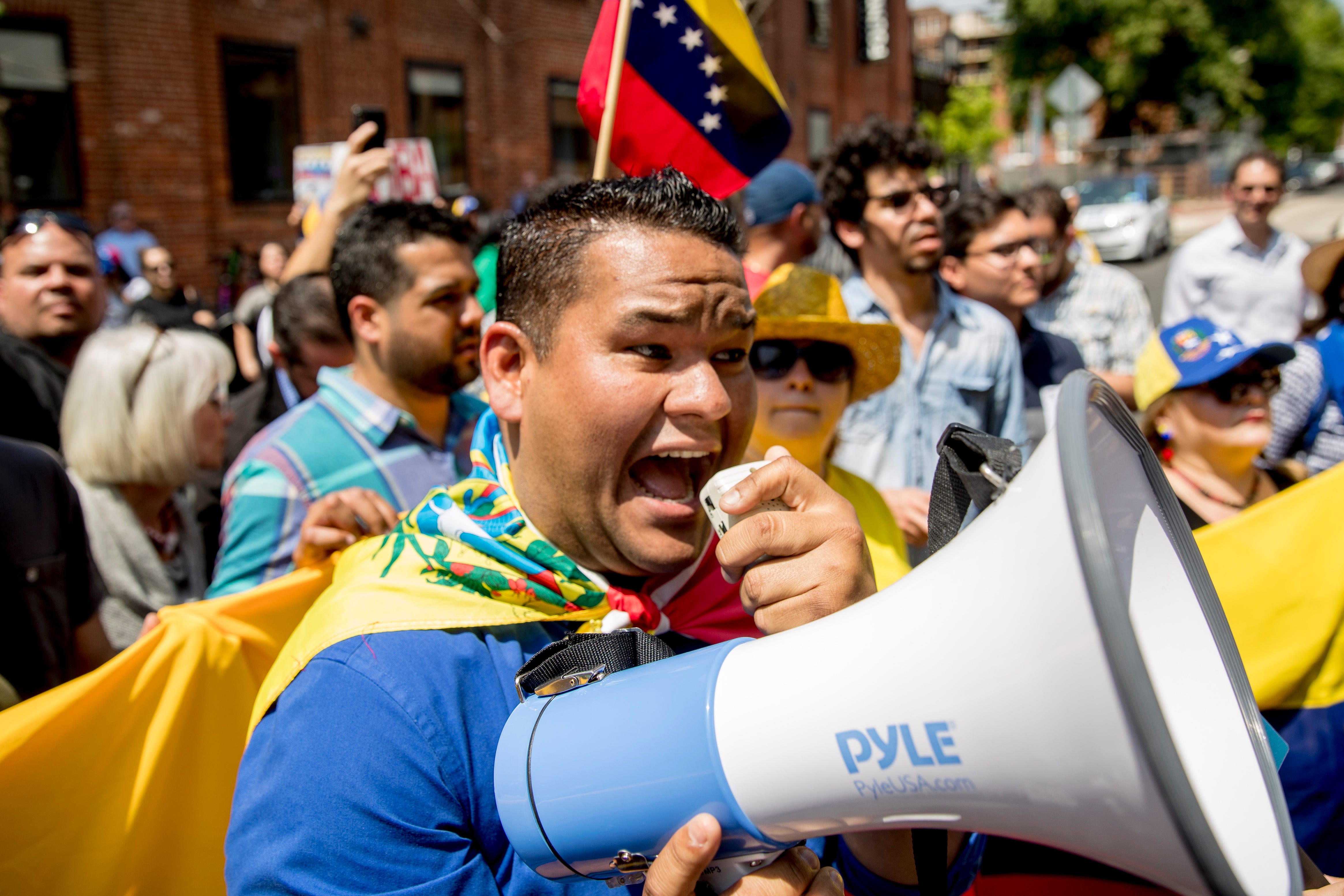 Pro interim government opposition leader Juan Guaido supporters yell chats towards pro Nicolas Maduro supporters outside of the Venezuelan Embassy in Washington, April 30, 2019.