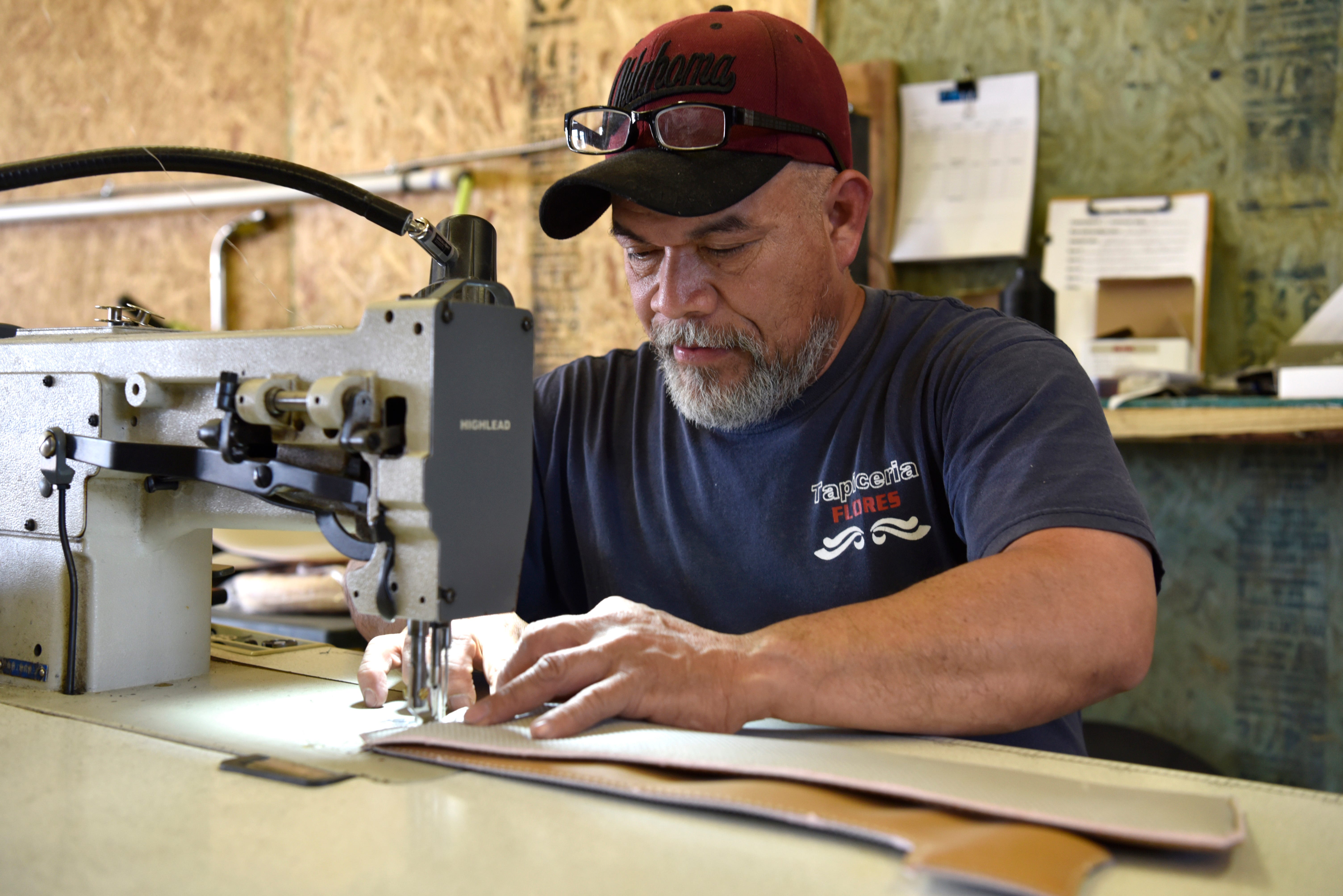 Polo Geronimo sews together upholstery pieces for a Ford Excursion at  Custom Autos By Tim in Guthrie, Oklahoma.