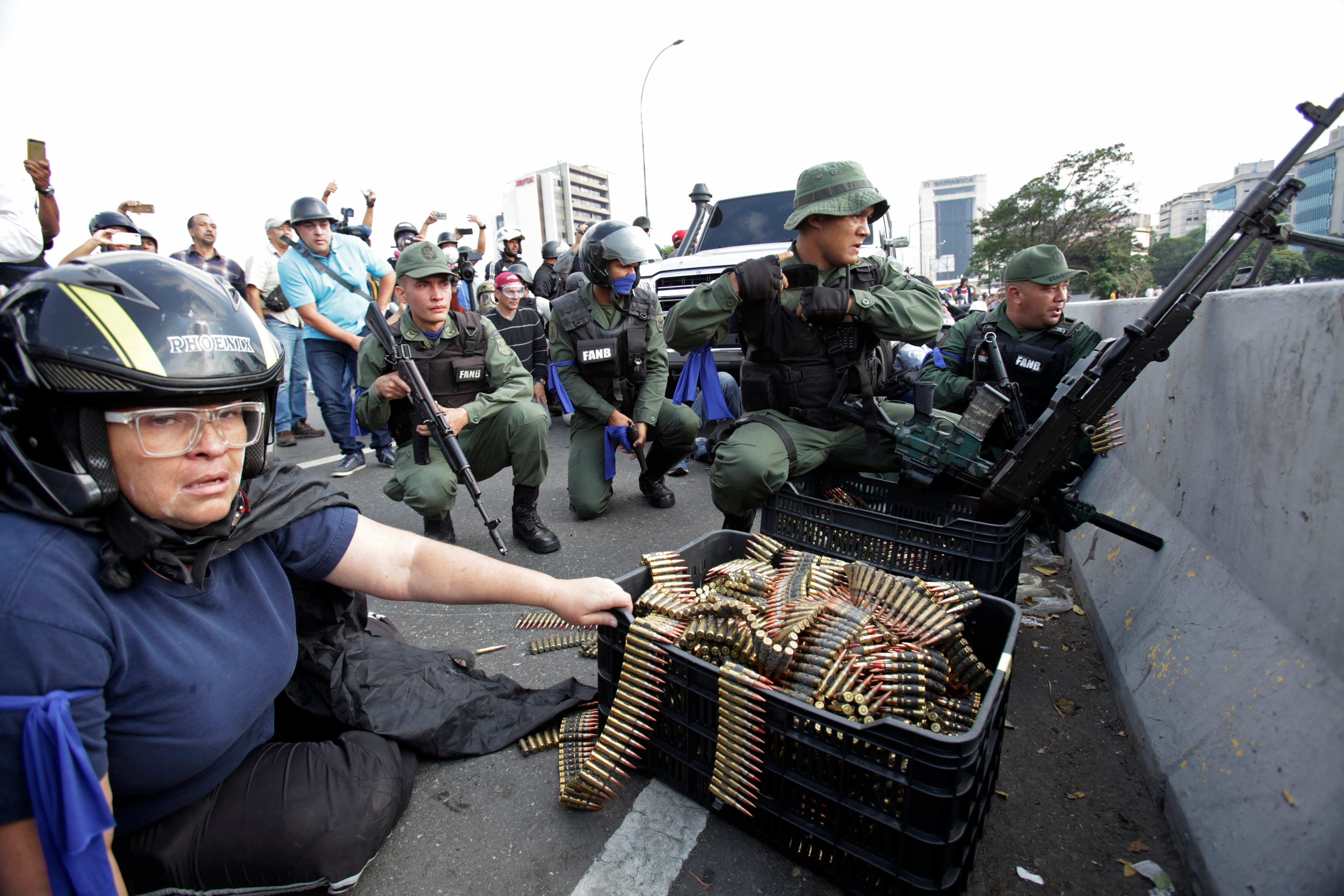 An anti-government protester sits by ammunition being used by rebel troops rising up against the government of Venezuela ' s President Nicolas Maduro in Caracas, Venezuela, April 30, 2019.