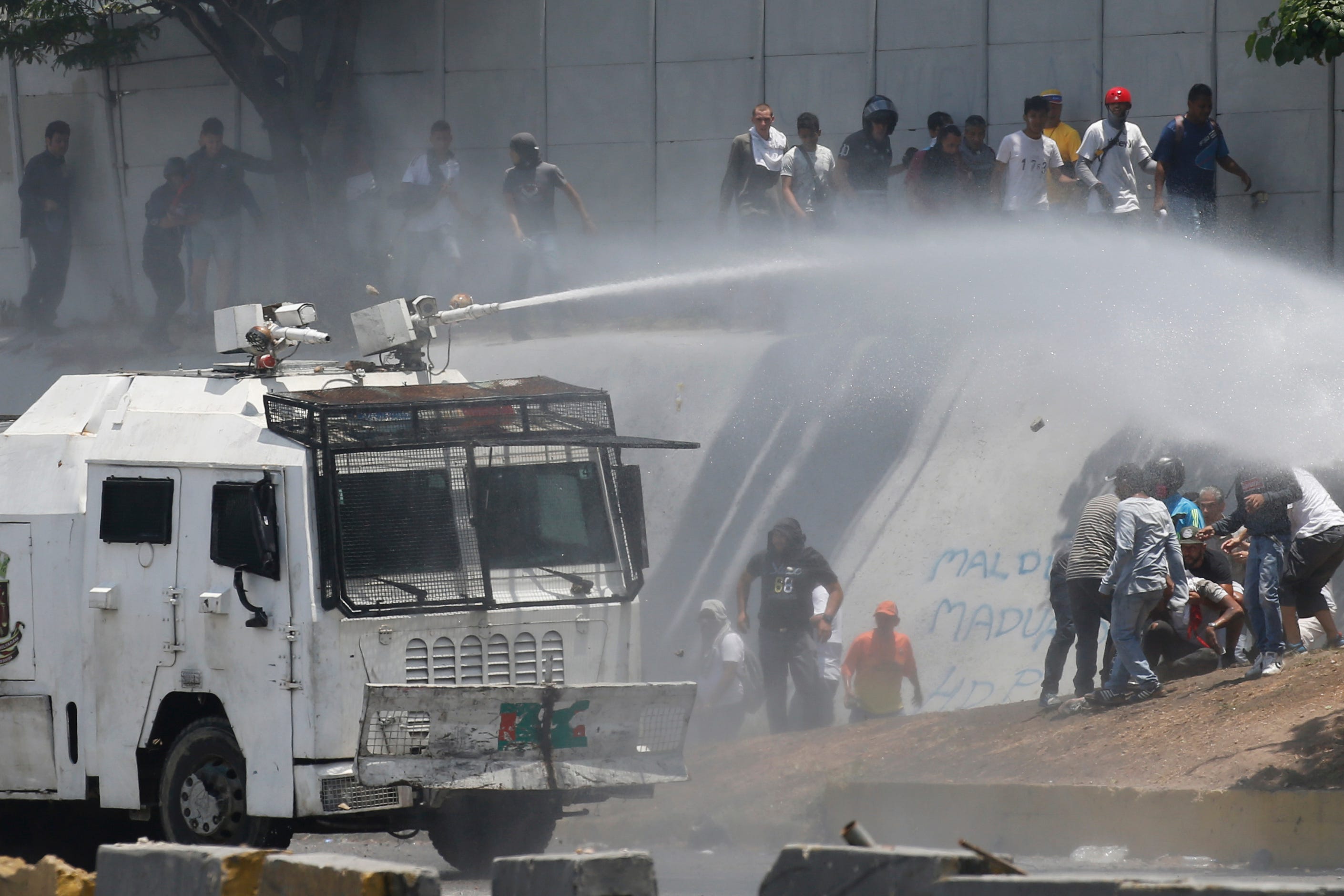 A Bolivarian National Guard water canon sprays opponents of Venezuela's President Nicolas Maduro during an attempted military uprising and anti-government protests in Caracas, Venezuela, Tuesday, April 30, 2019. Venezuelan opposition leader Juan Guaido and jailed opposition leader Leopoldo Lopez took to the streets with a small contingent of heavily armed troops early Tuesday in a bold and risky call for the military to rise up and oust Maduro.
