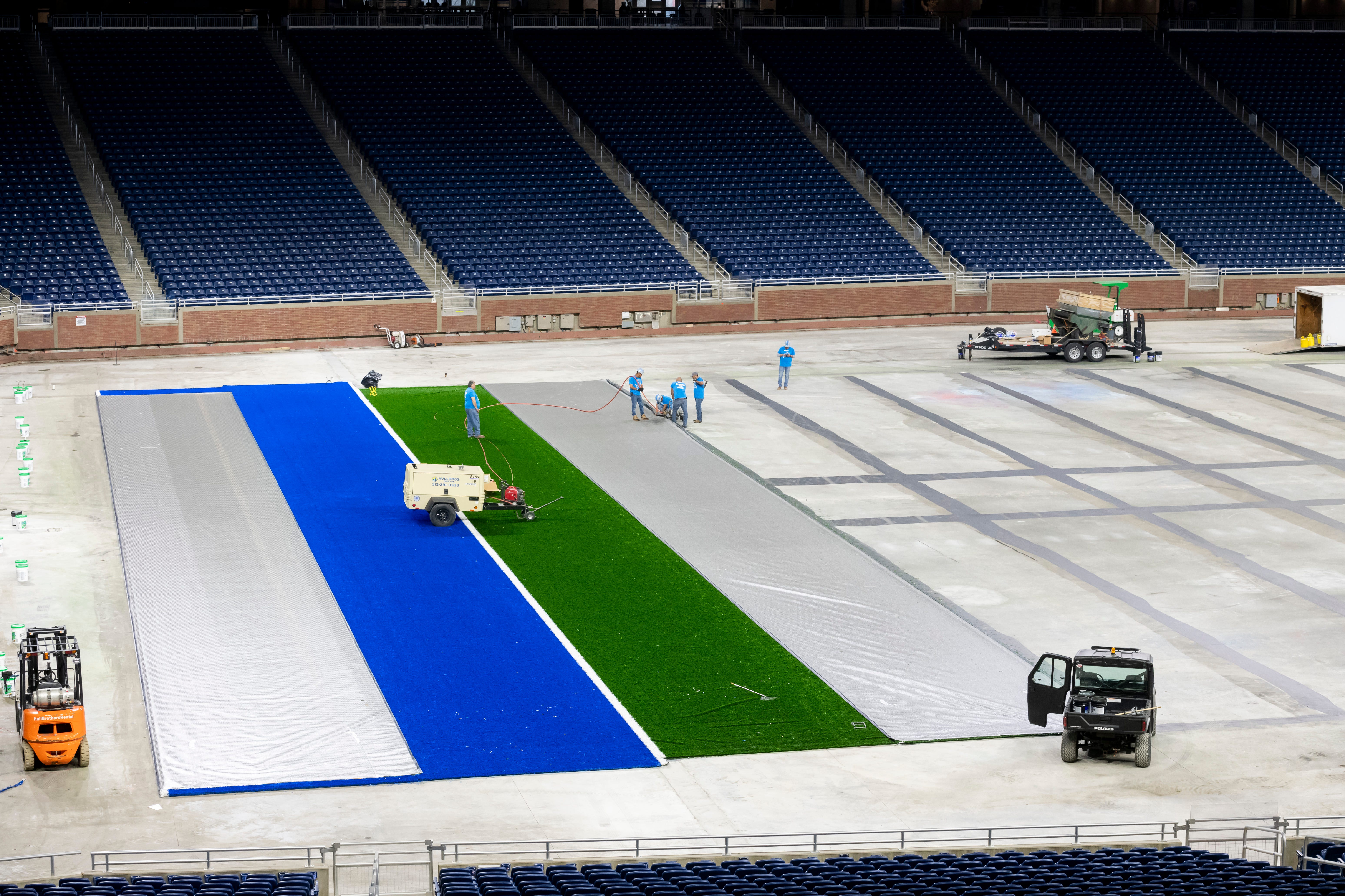 Employees from FieldTurf install a new playing surface at Ford Field.