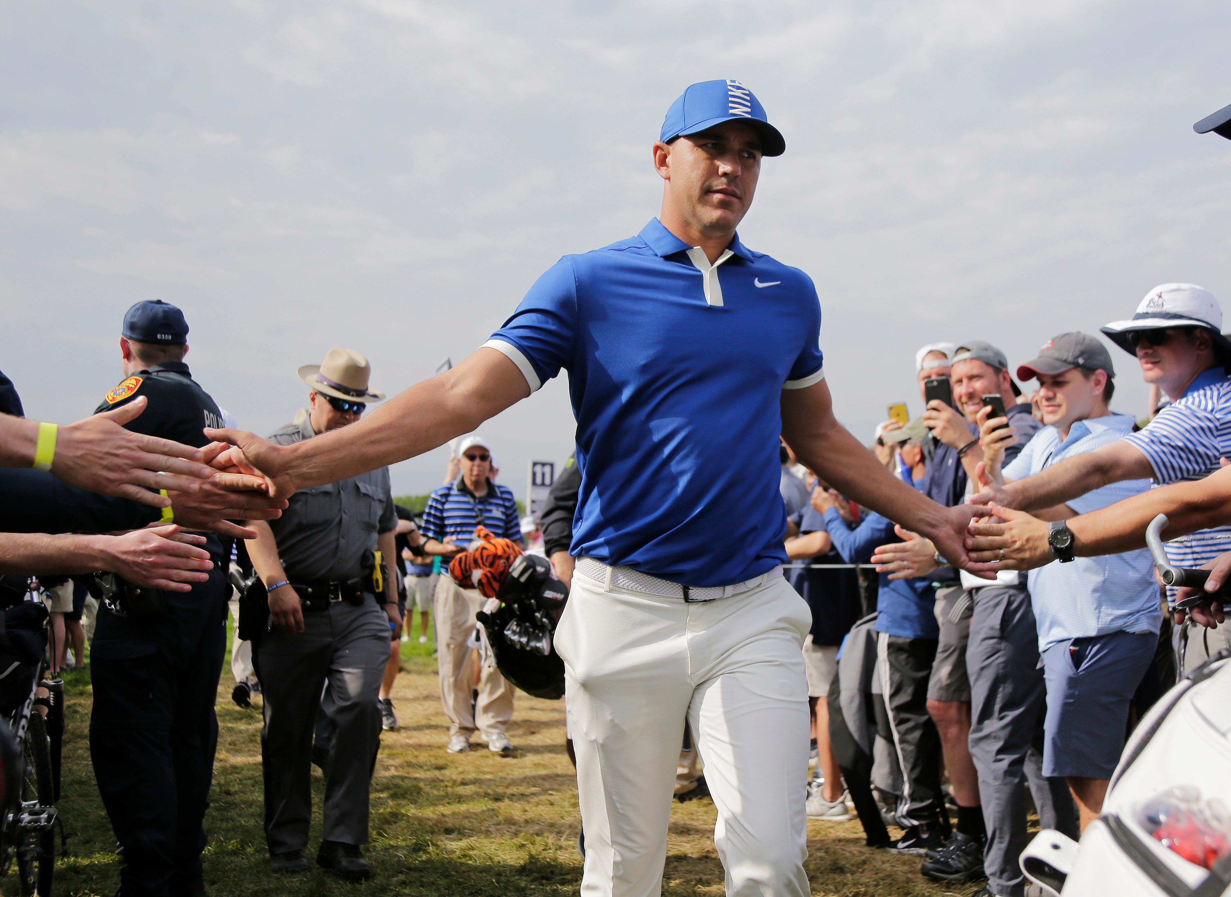 Brooks Koepka greets spectators as he walks to the 12th tee during the second round of the PGA Championship on Friday.