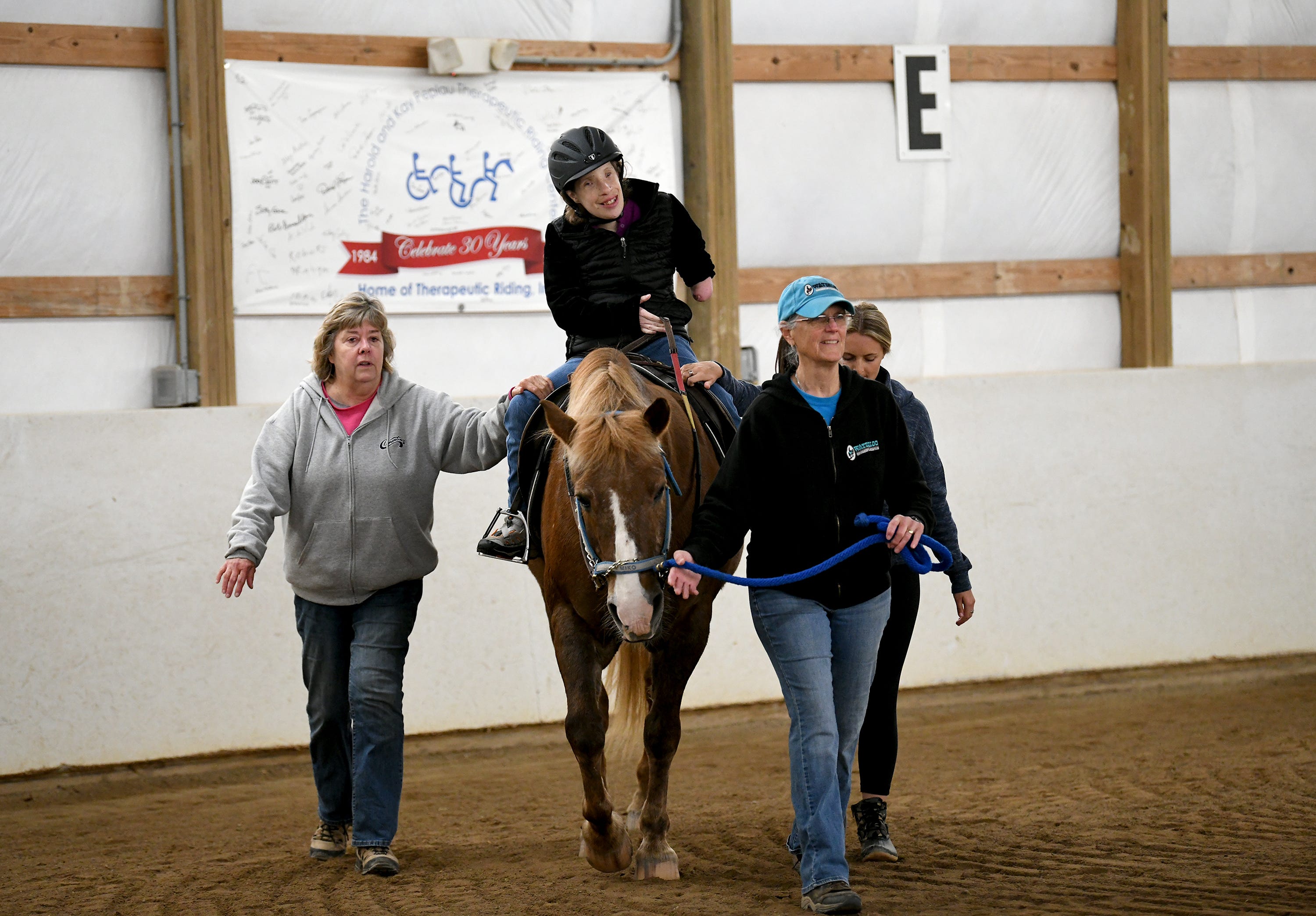 Elizabeth Lerchin rides the horse Miko, with the help of volunteers Louise Moore, left, Pat Whitworth, leading the horse, and Ellie Clark.