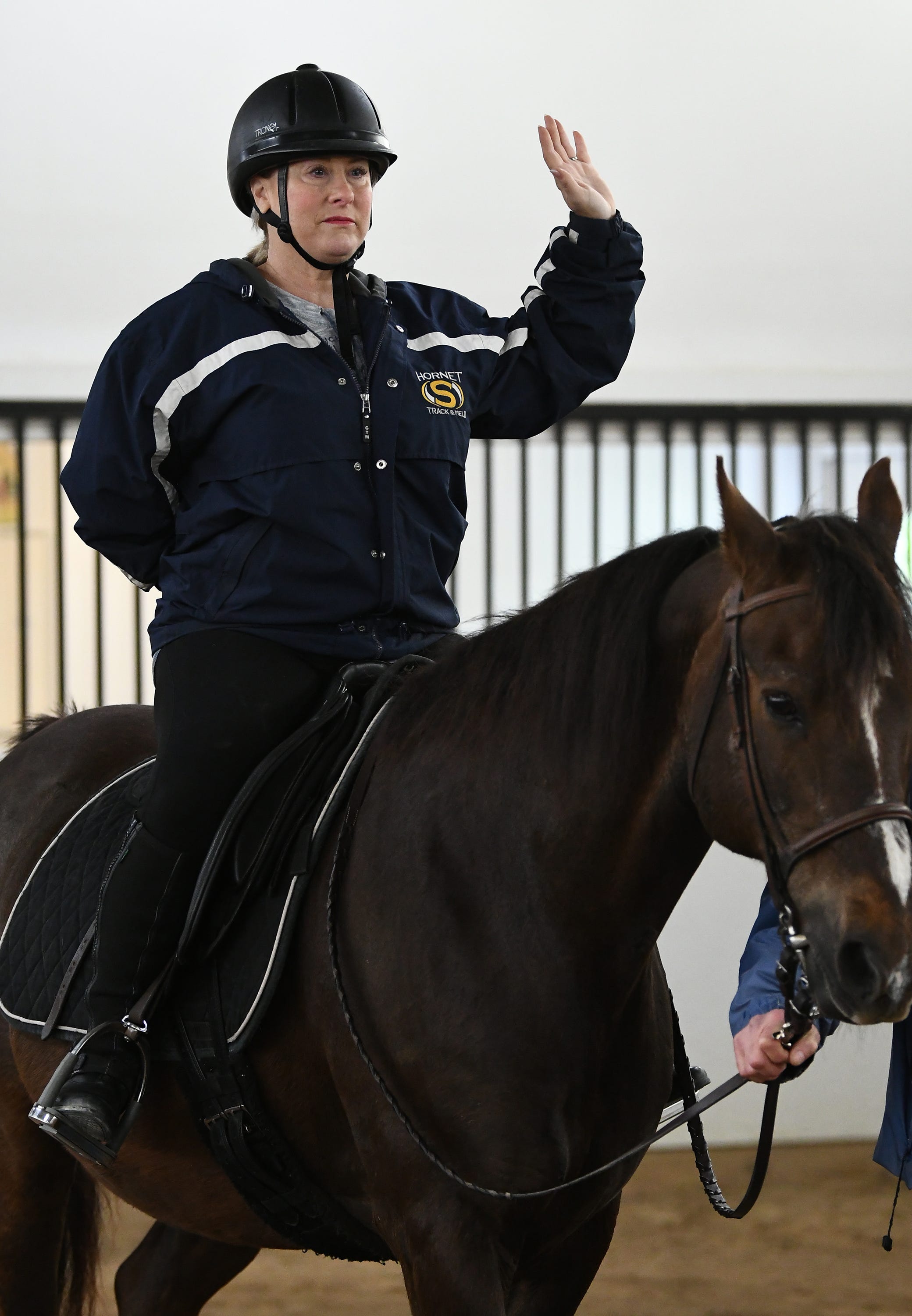 Michelle Witzig practices her balance atop the horse Hey Dobbs, by riding with no hands during her therapeutic riding session.