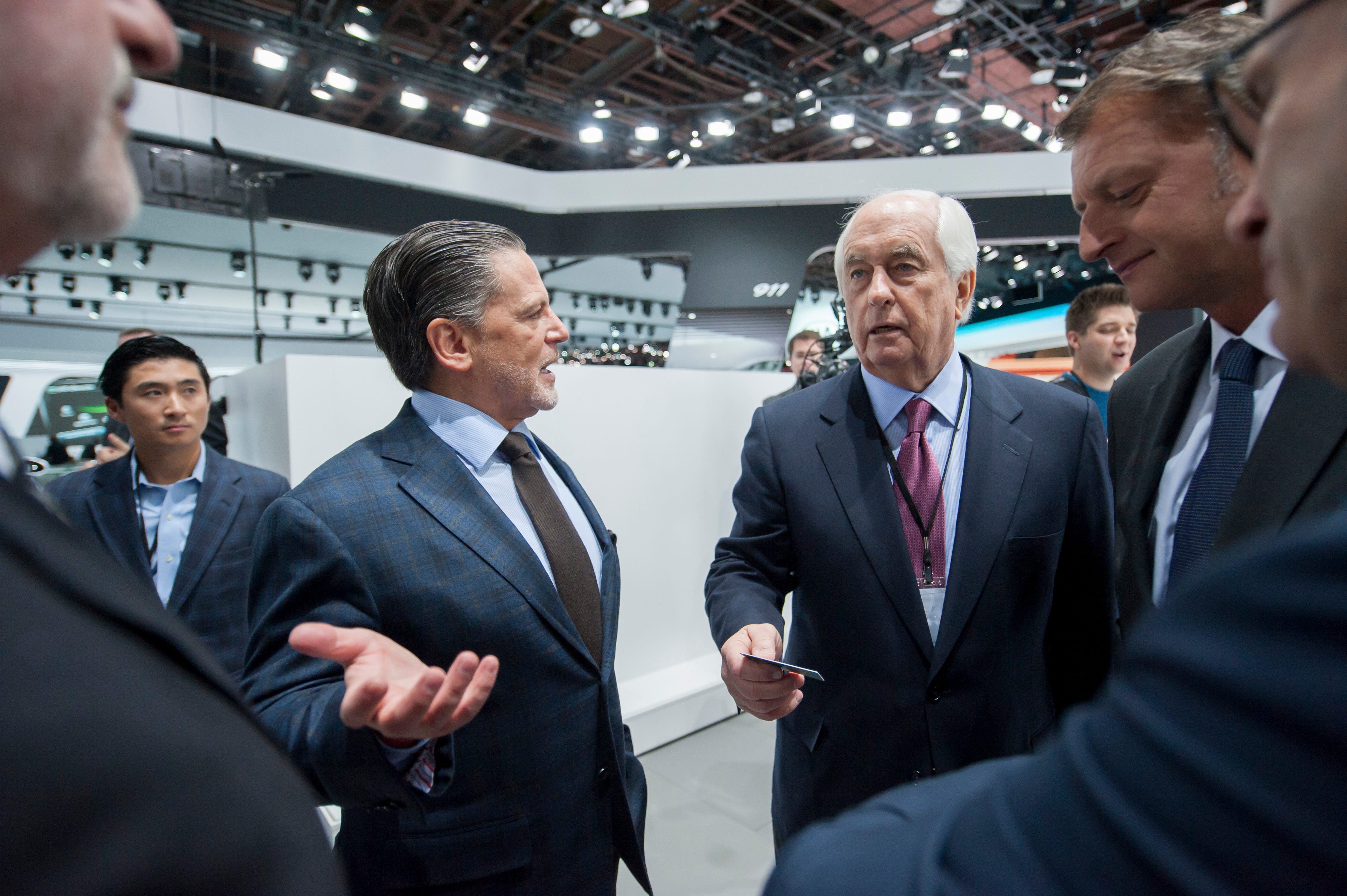 Dan Gilbert, left, and Roger Penske chat on the main floor during the North American International Auto Show at Cobo Hall in Detroit January 12, 2015.