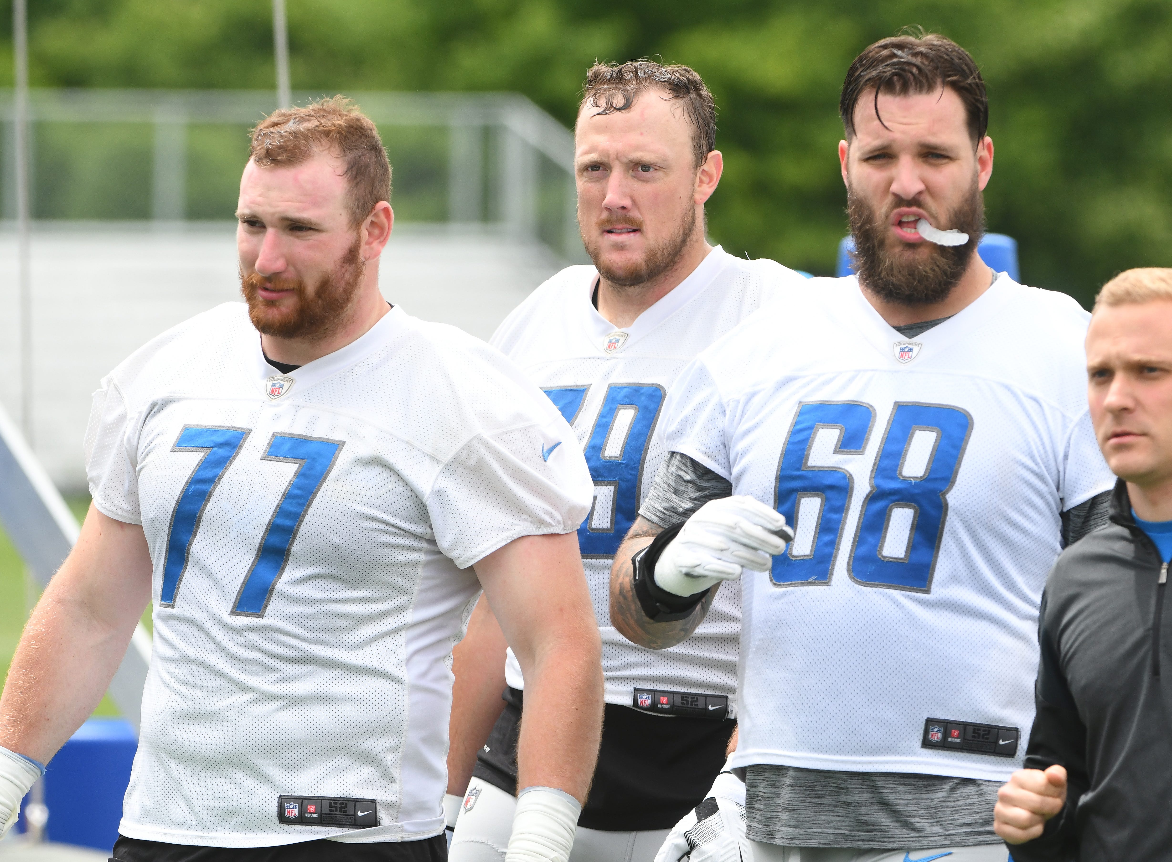 Lions offensive linemen Frank Ragnow, Kenny Wiggins and Taylor Decker walk off the field after practice.