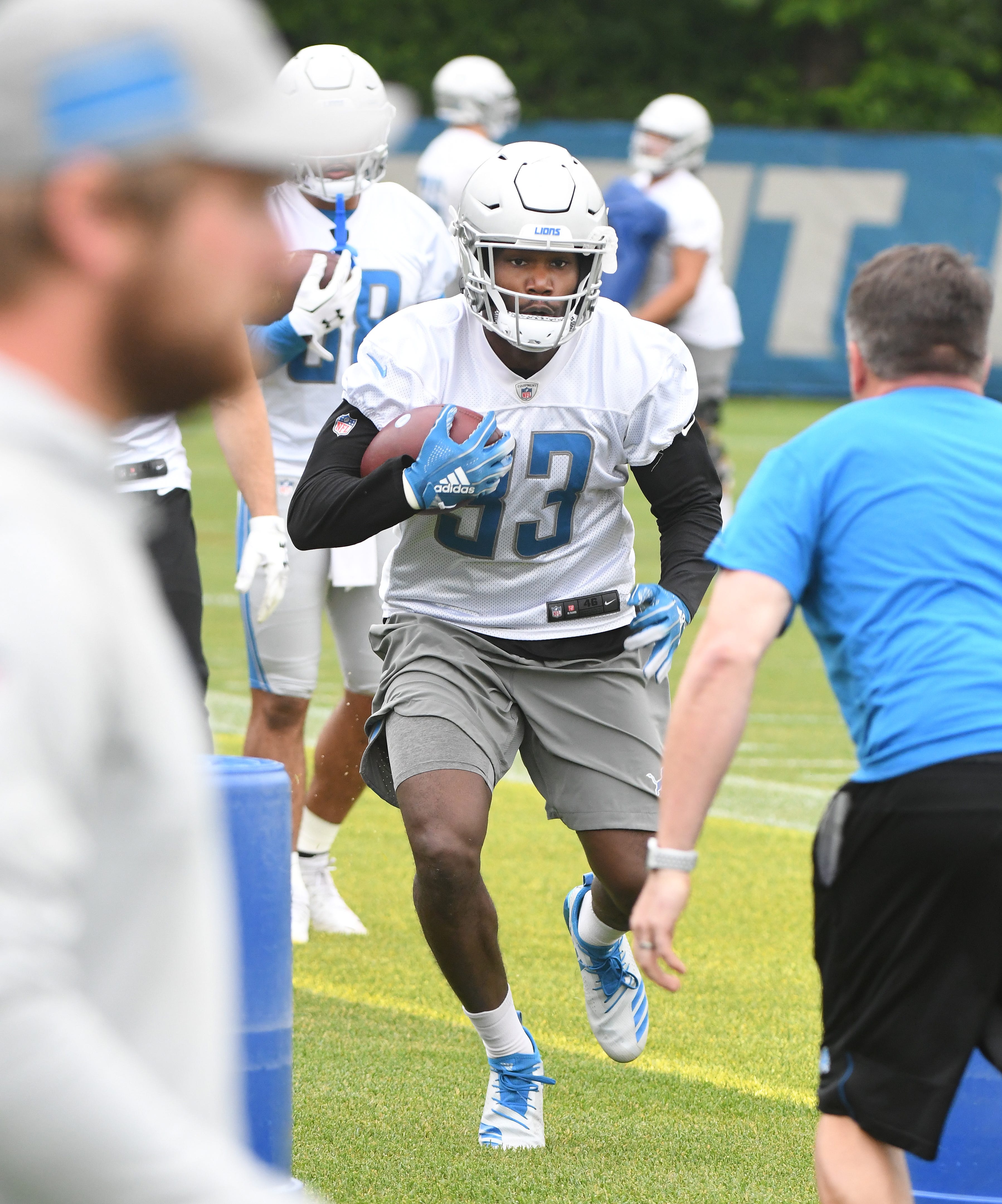 Lions running back Kerryon Johnson looks for the hole during drills.