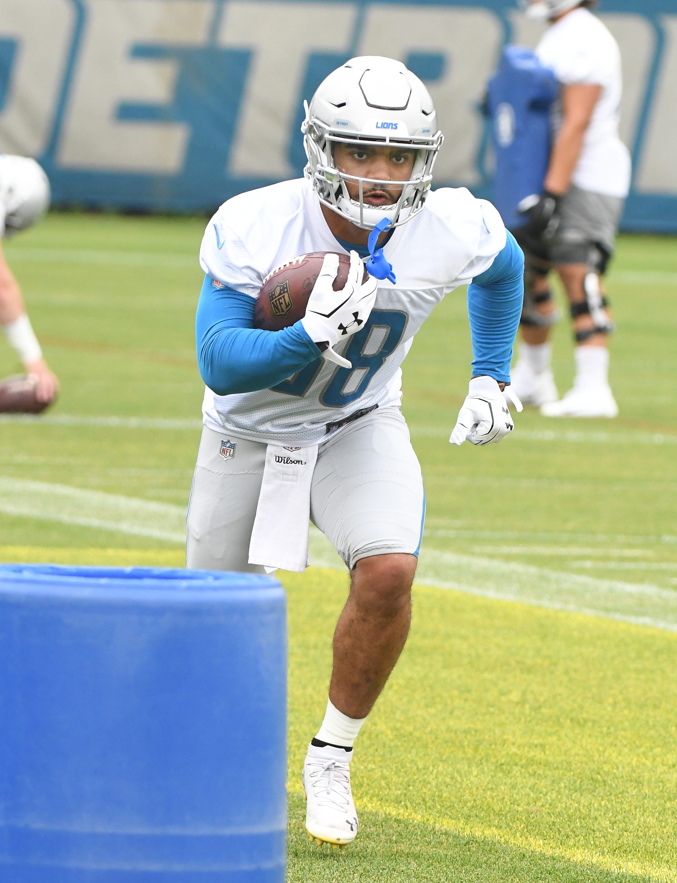 Lions running back Ty Johnson works around the obstacles during drills.