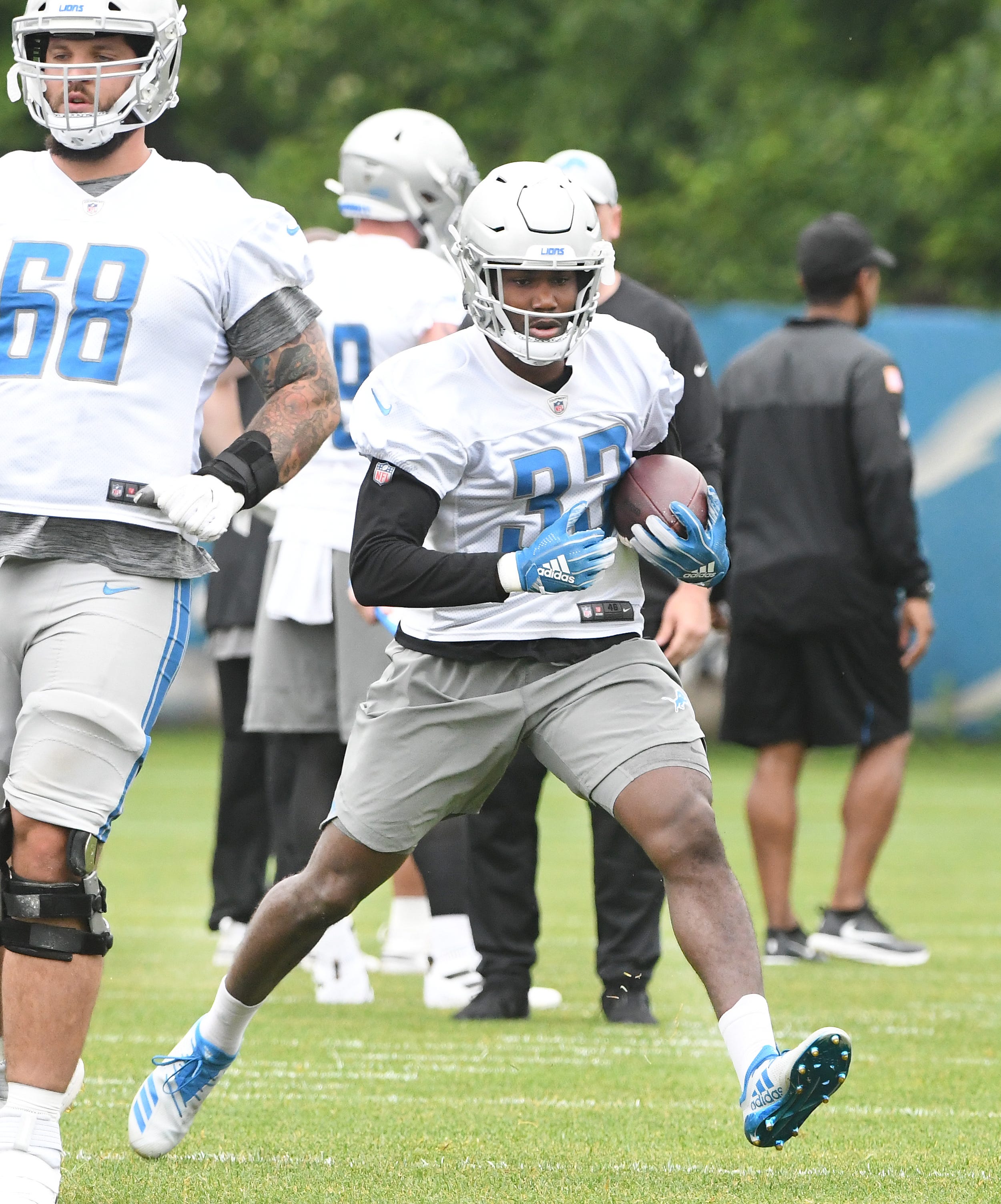 Lions running back Kerryon Johnson cuts from behind lineman Taylor Decker during drills.