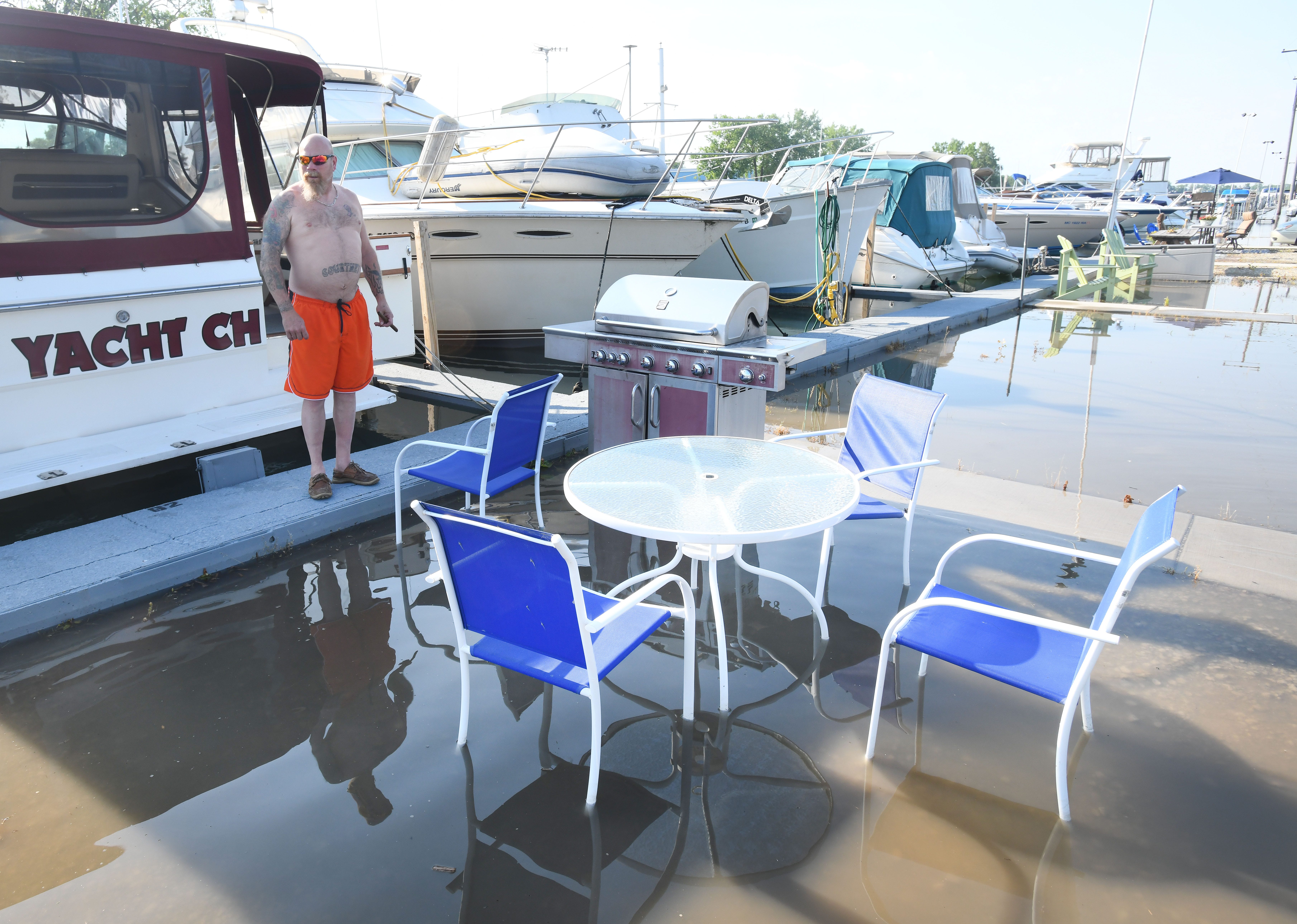Willie Brown enjoys some time at his boat in the Humbug Marina in Gilbralar but finds his table, chairs and grill in water in what is usually a dry parking lot.