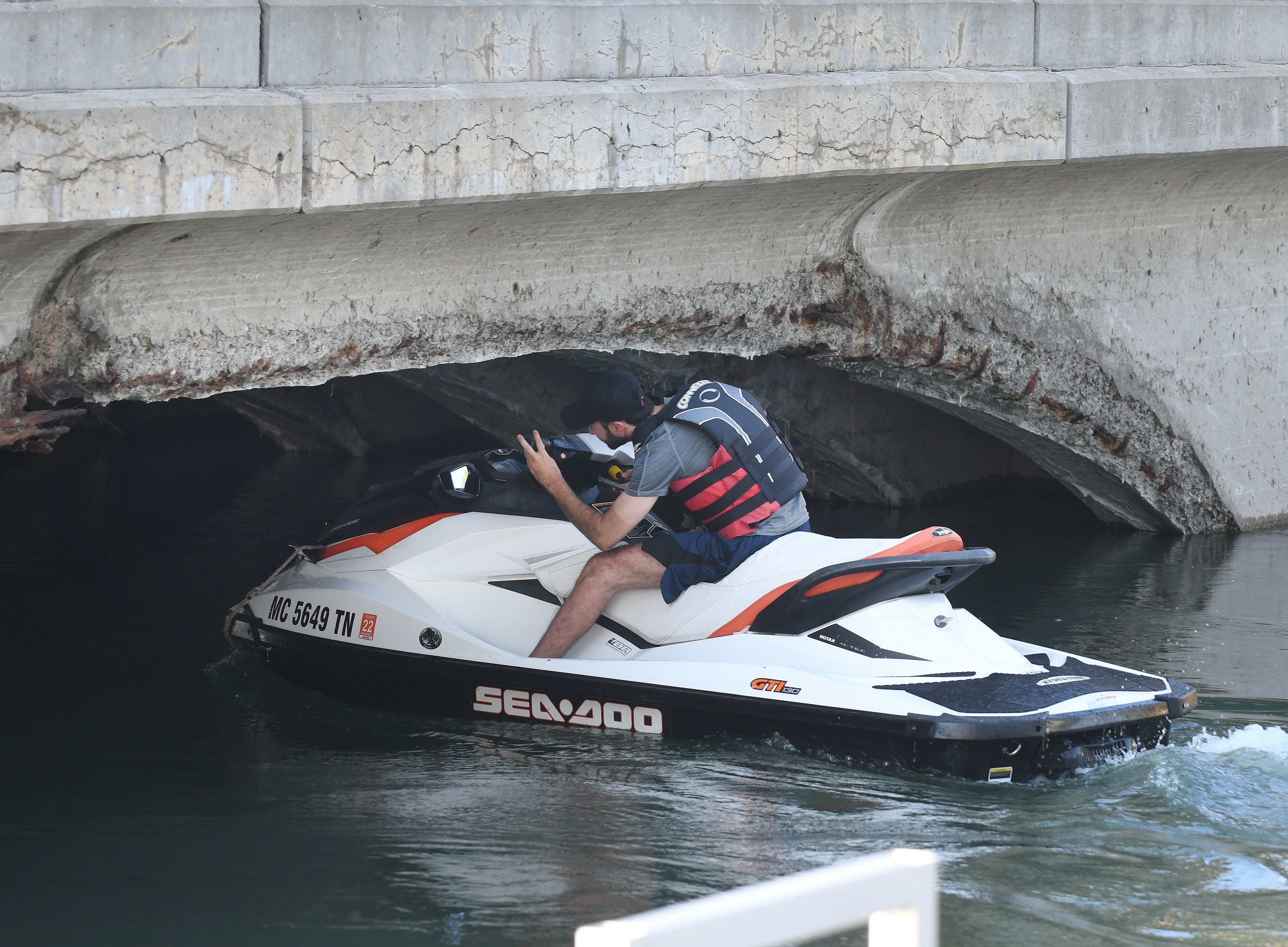 A jet skier squeezes under a bridge in downtown Gibraltar, Michigan on July 1, 2019.