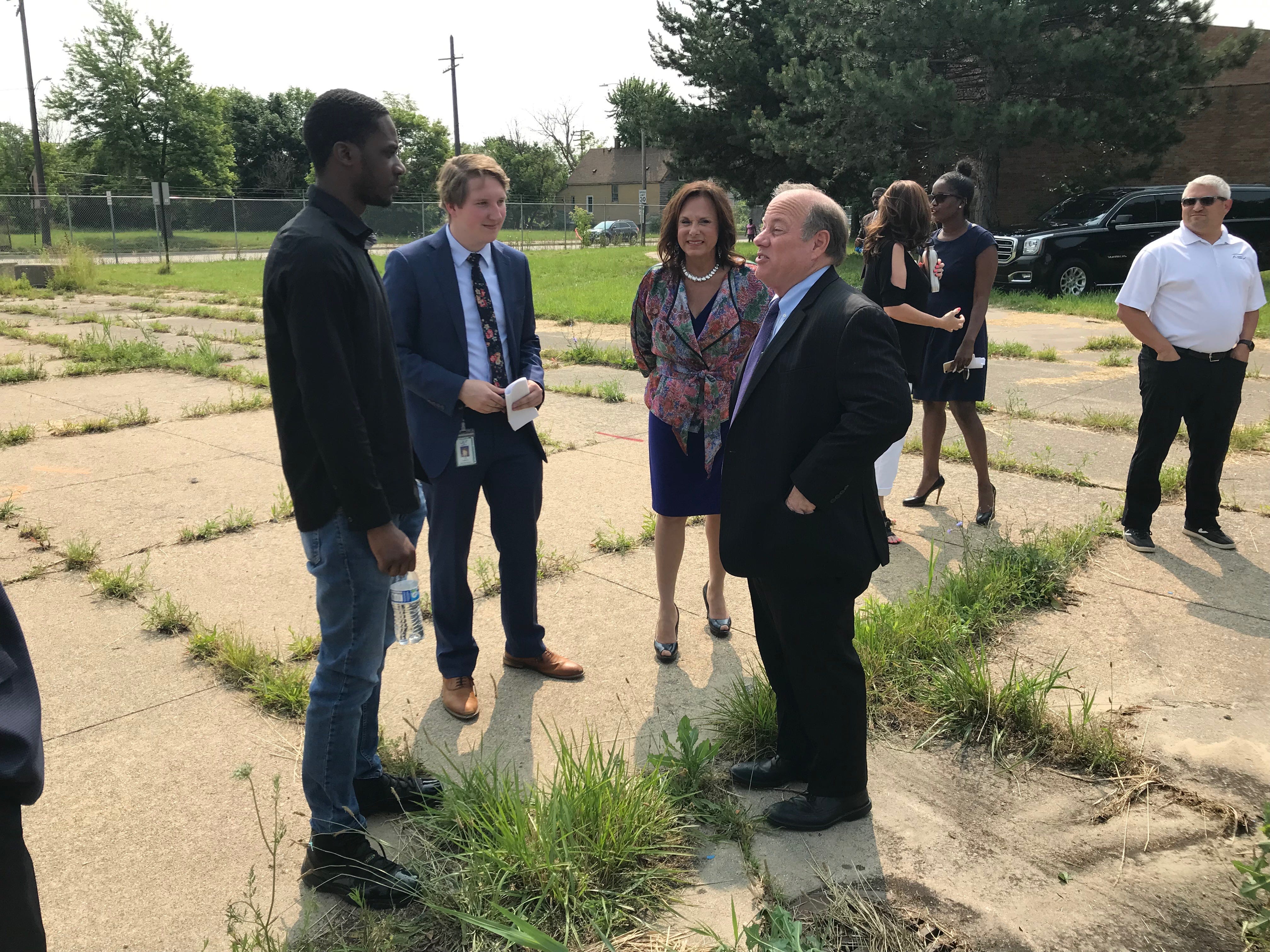 Dakkota Integrated Systems CEO Andra Rush, center, listens as Detroit Mayor Mike Duggan talks to 23-year-old Branden Horner, who came to the announcement of a $55-million manufacturing facility Tuesday hoping to apply for a job.