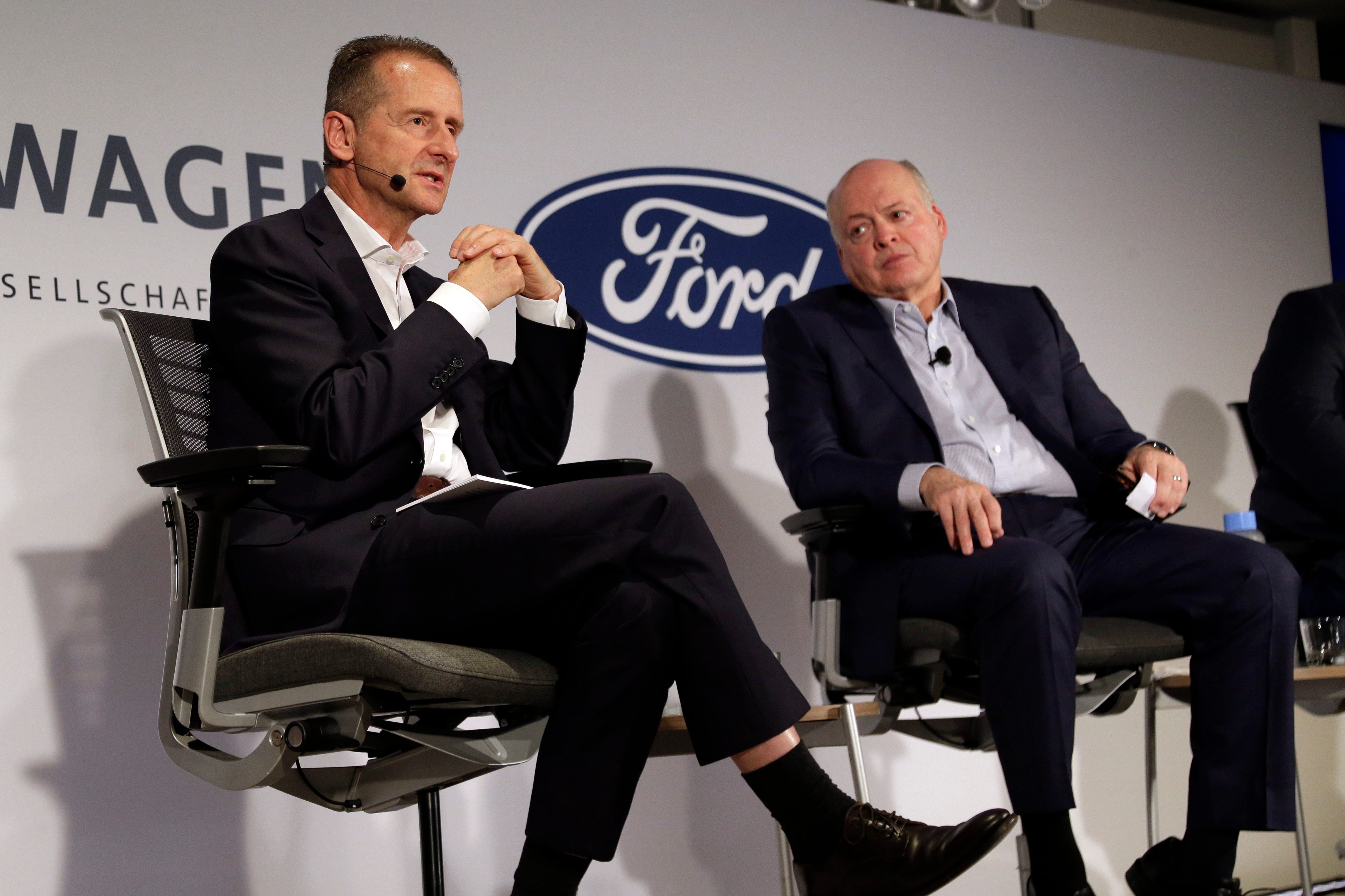 Volkswagen AG CEO Herbert Diess, left, and Ford Motor Co. CEO Jim Hackett  at  a news conference Friday in New York. The two automakers will to share electric vehicle platforms and self-driving software, potentially saving each company hundreds of millions of dollars.