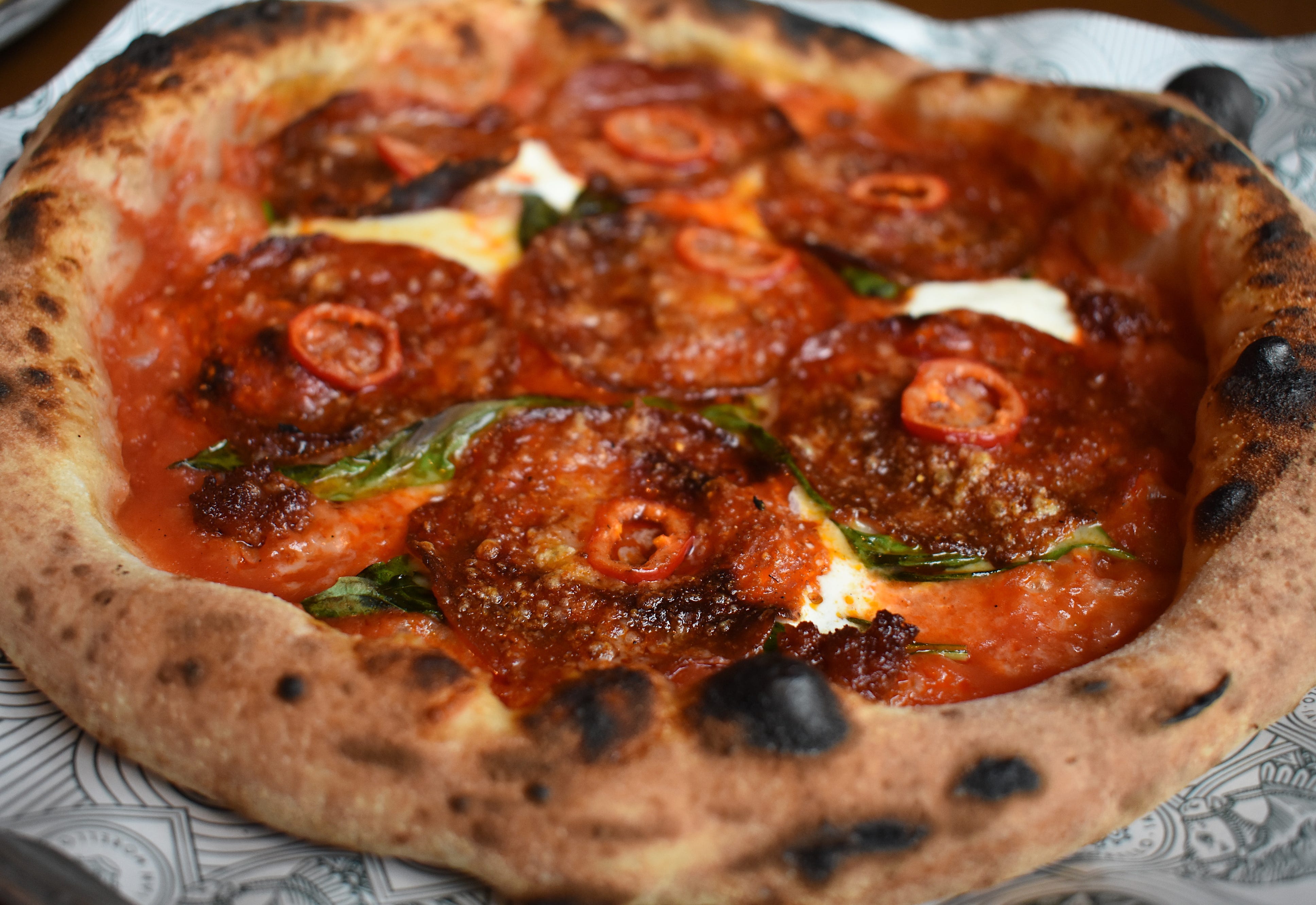An "OG" pizza, straight outta the wood-fired oven, is topped with pepperoni, 'nduja, and Fresno chilies.