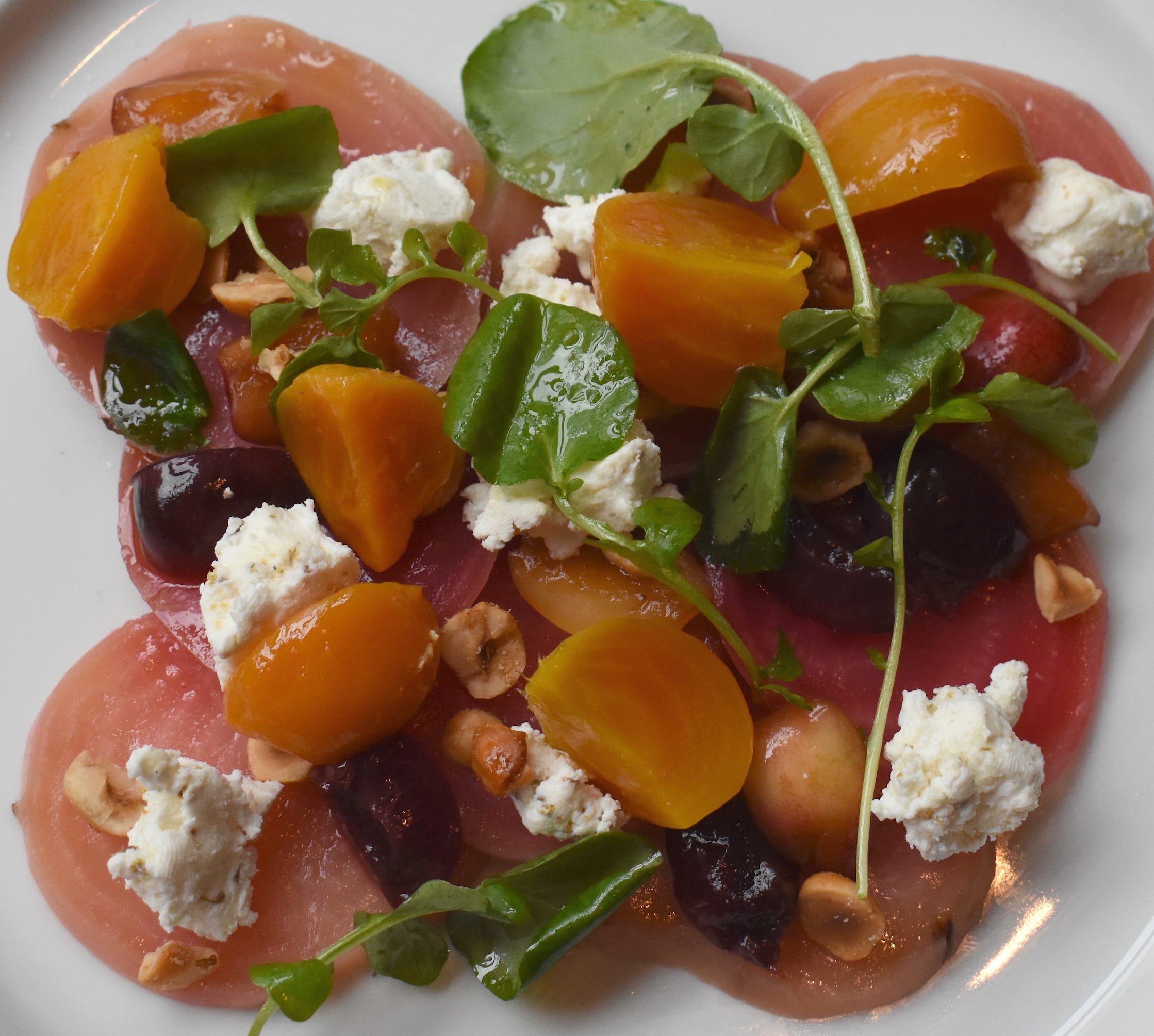 A beet carpaccio antipasti is complimented by Idyll Farms goat cheese, hazelnuts and pickled cherries.