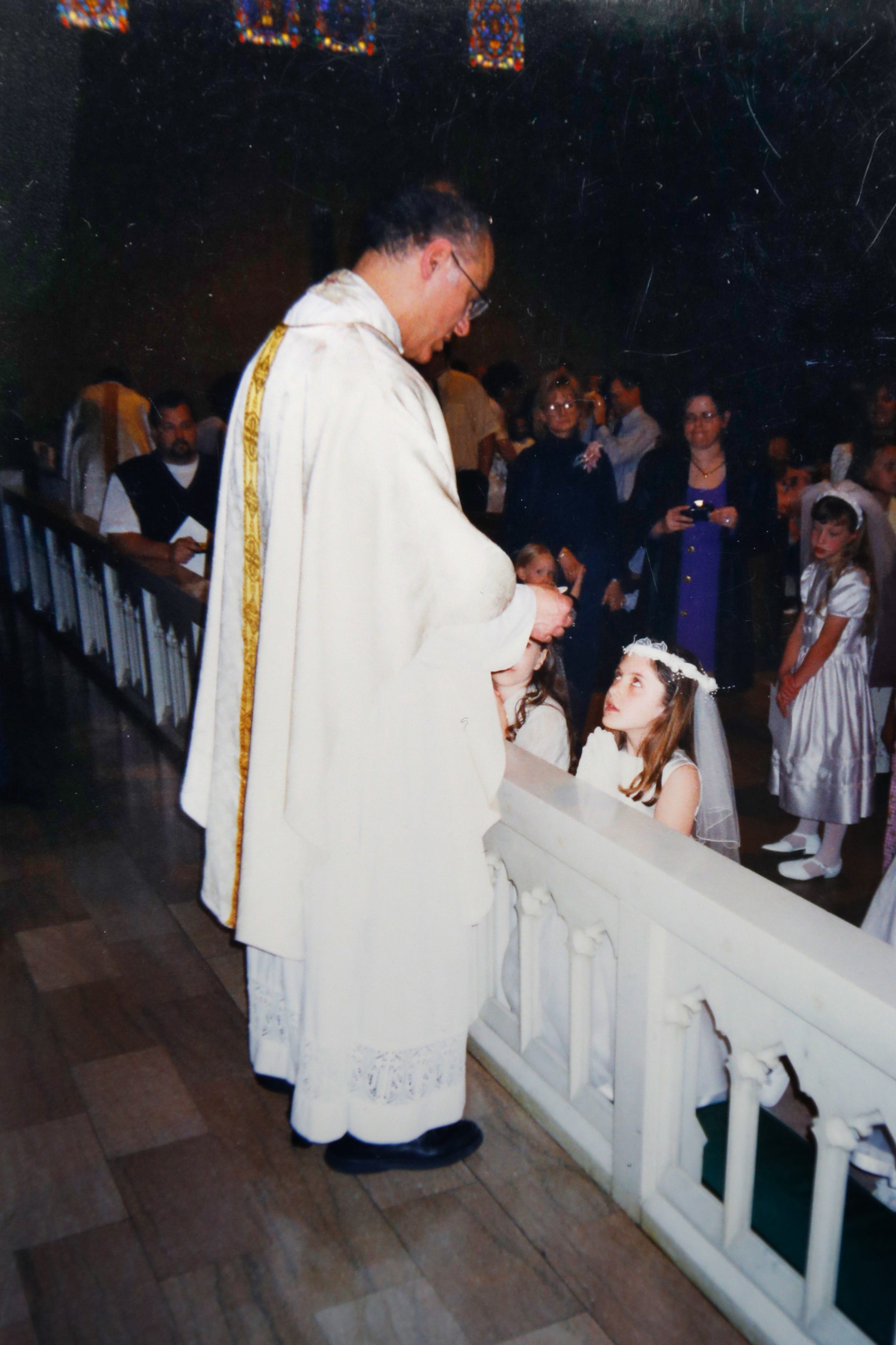 This photo provided by Mary Rose Maher shows her as a child during her First Communion with the Rev. Eduard Perrone at The Assumption of the Blessed Virgin Mary Church in Detroit.