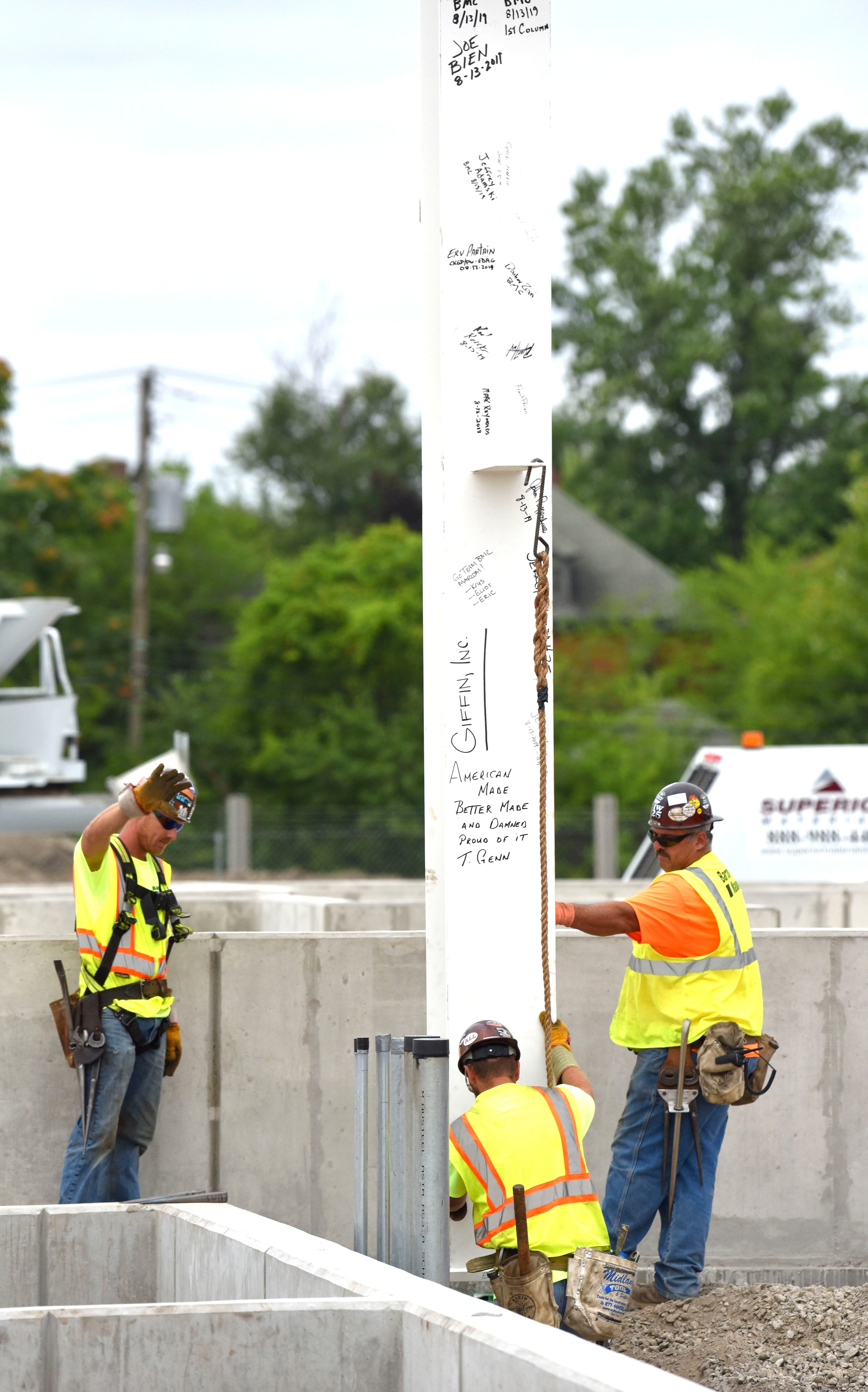 Workers set the first vertical column for the new paint shop.