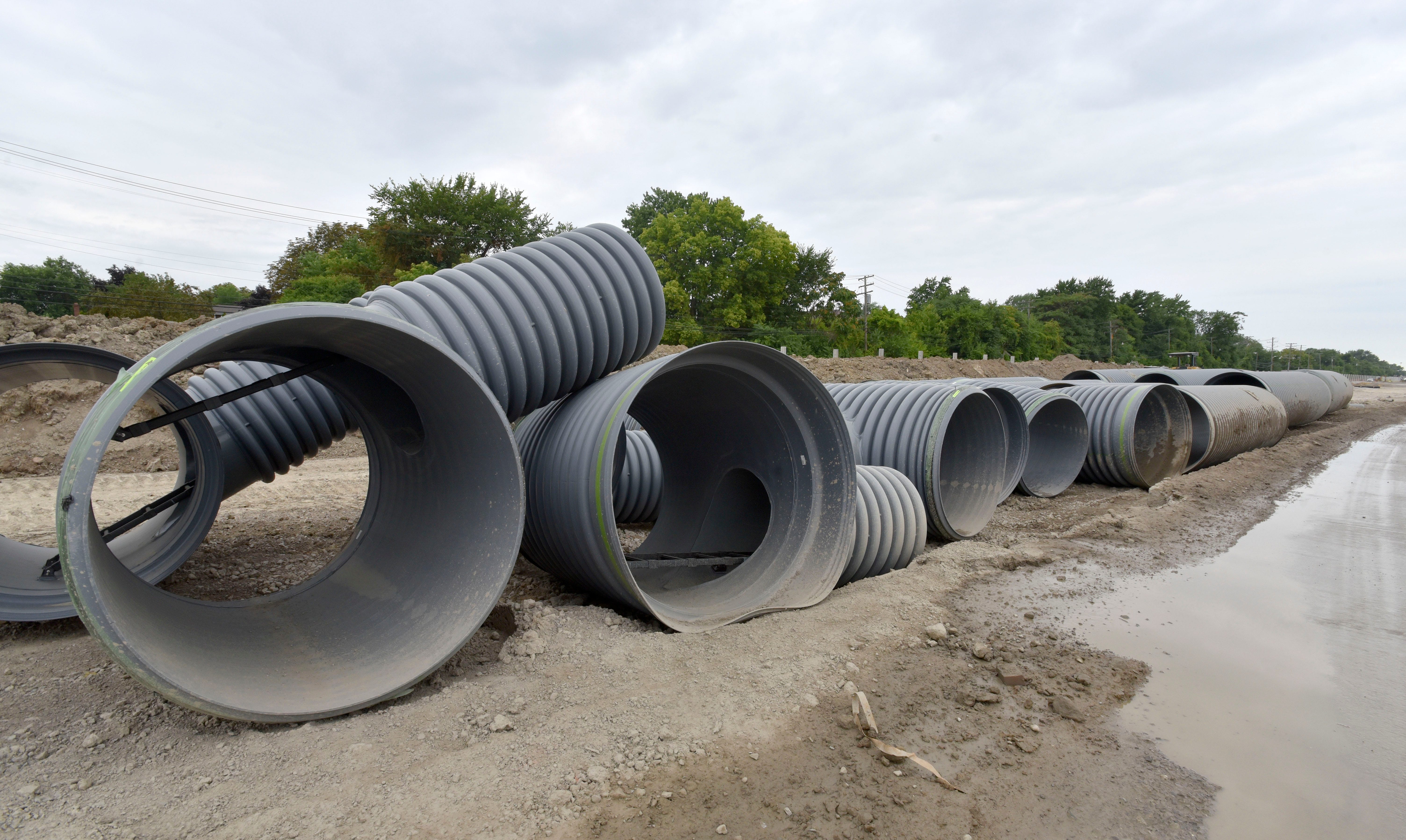 Underground storm sewer pipes are staged before being placed under the employees parking lot, which was St. Jean.